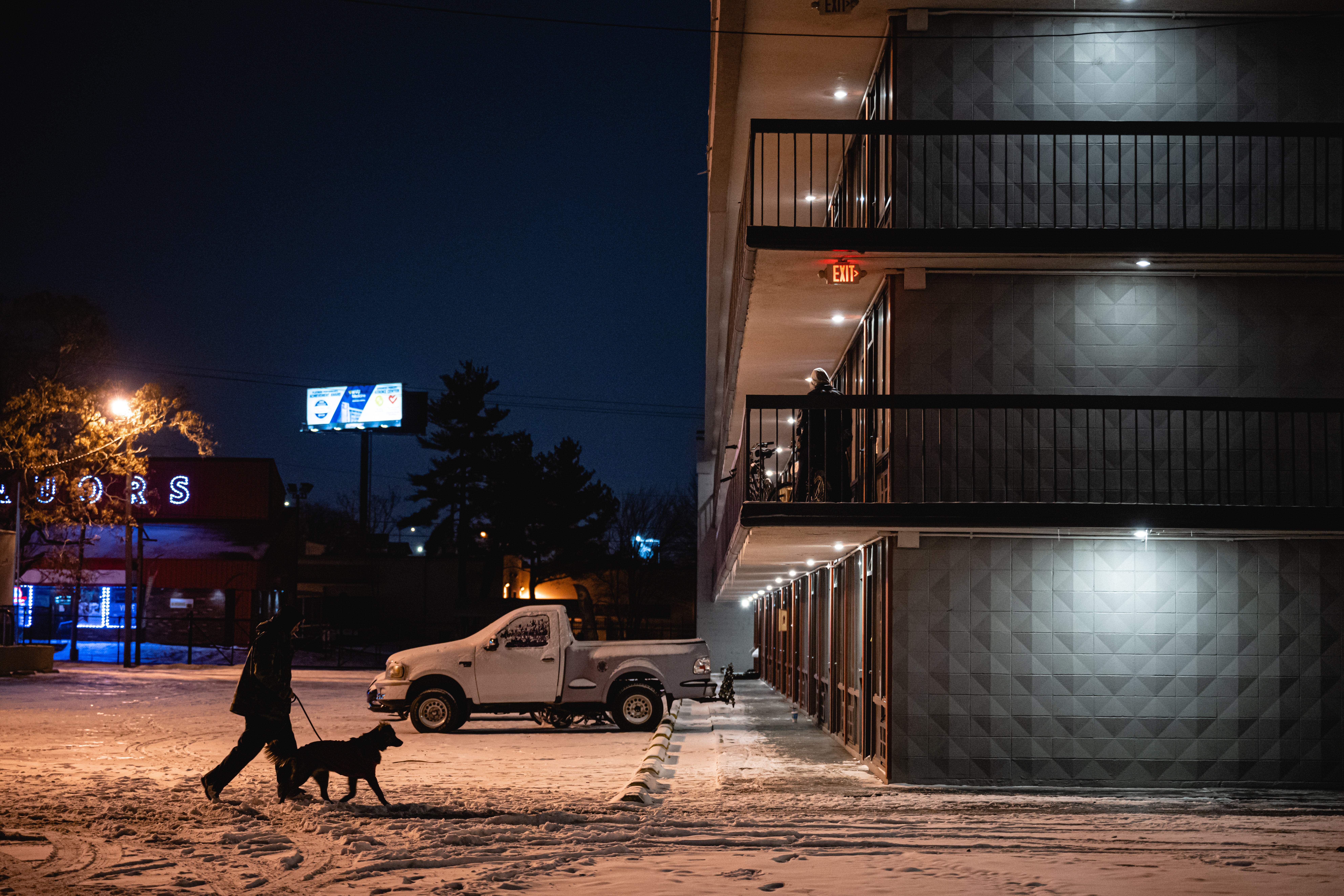 A person walks their dog through the parking lot of a hotel being used to house homeless individuals and families on December 23, 2022 in Louisville, Kentucky