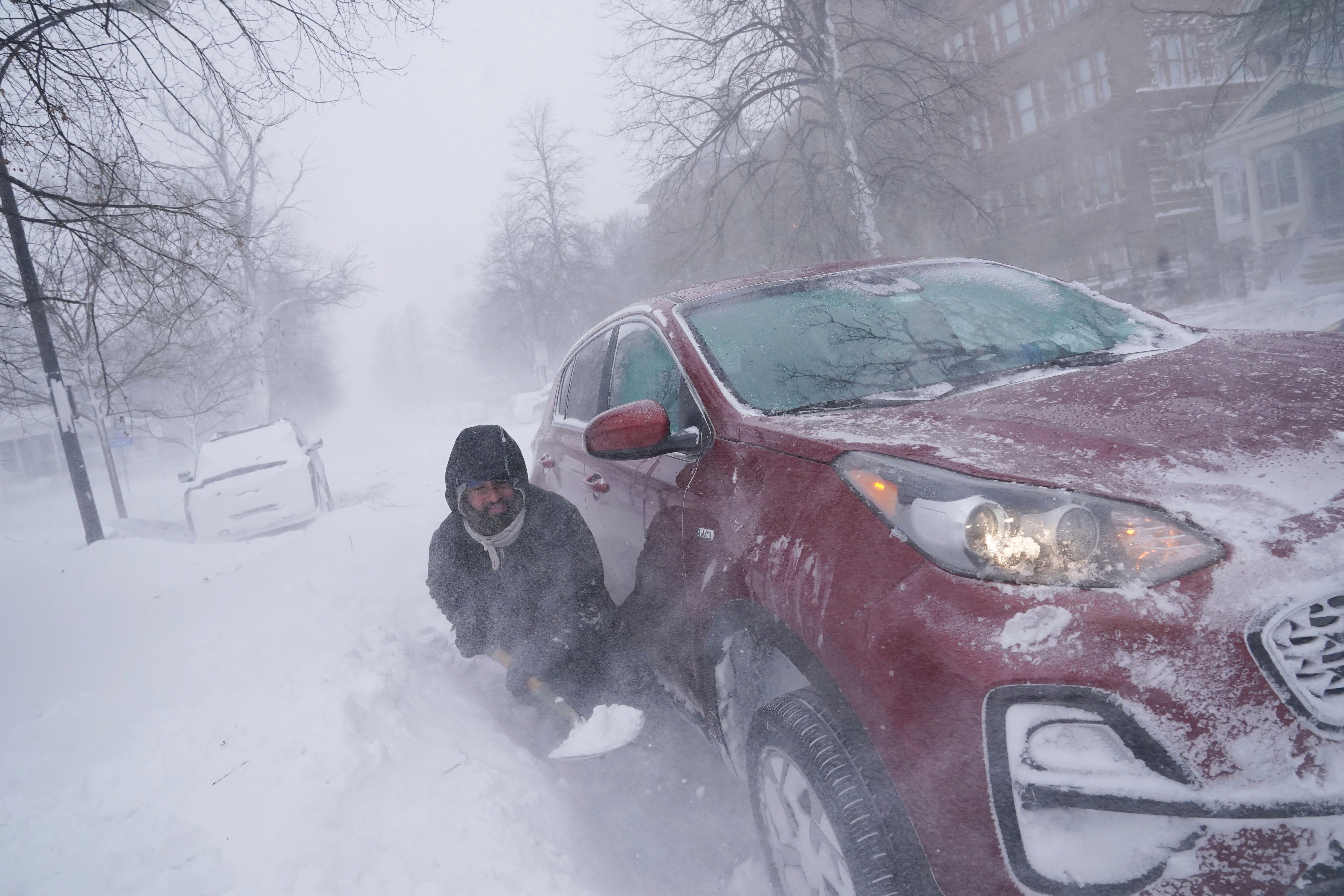 Gamaliel Vega tries to dig out his car on Lafayette Avenue after he got stuck in a snowdrift about a block from home while trying to help rescue his cousin