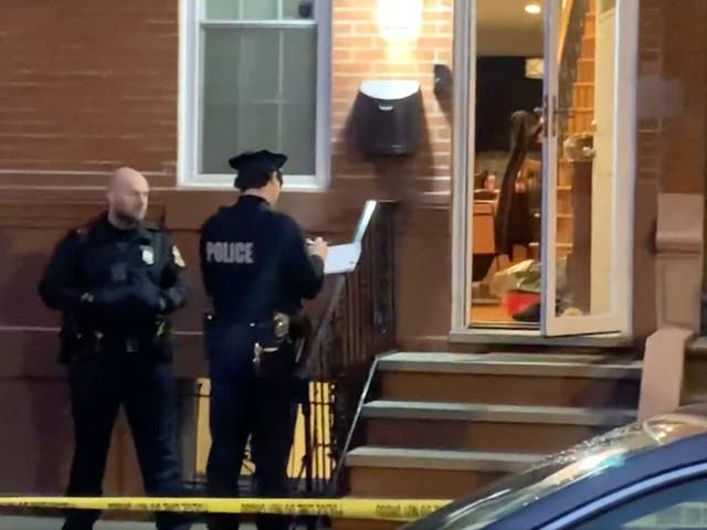 <p>Police in Philadelphia outside a rowhouse where a trail of blood led them to human remains in a freezer. The body had a bag wrapped around its head and a bloody knife was found nearby</p>
