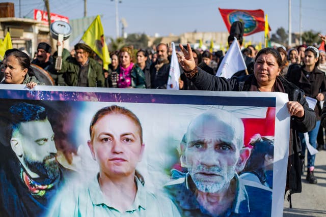 <p>Kurds hold a banner featuring victims of the Paris shooting at a protest in Syria’s northeastern city of Hasakeh on Sunday</p>