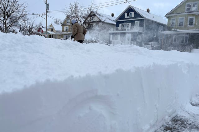 <p>Resident Martin Haslinger clears snow from the front of his house in Buffalo, New York on Christmas Day</p>