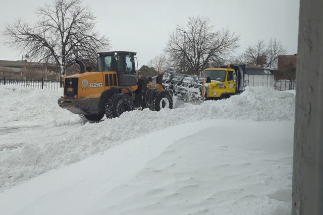 <p>Ploughs get stuck in the snow in downtown Buffalo, New York on Sunday evening</p>