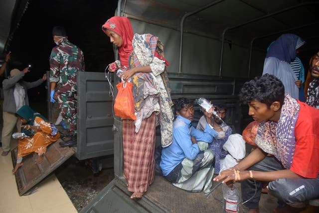 <p>Ethnic Rohingya people sit inside a military truck upon arrival at a temporary shelter after their boat landed in Pidie, Aceh province Indonesia on 26 December </p>