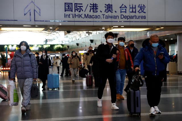 <p>Travellers walk with their luggage at Beijing Capital International Airport</p>