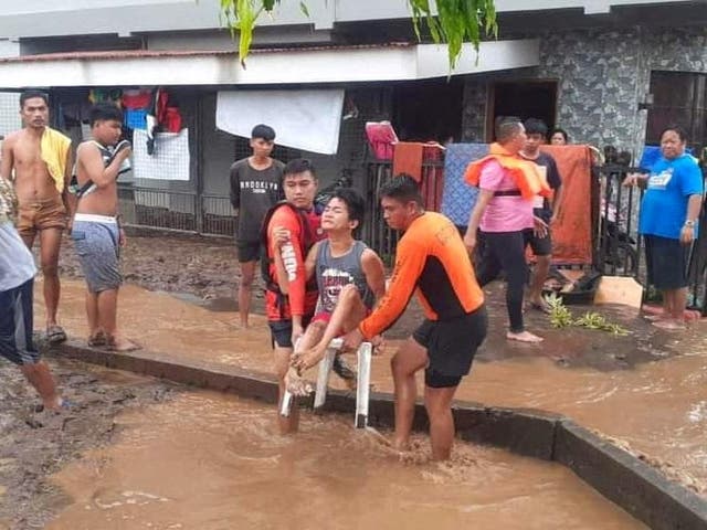 <p>Rescue workers help people affected by floods, in Plaridel, Misamis Occidental Province</p>