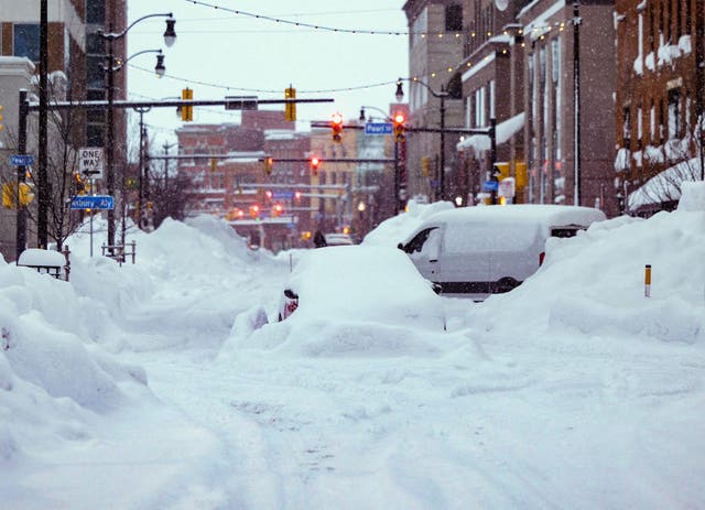 <p>Vehicles trapped under heavy snow in the streets of downtown Buffalo, New York, on 26 December, 2022</p>