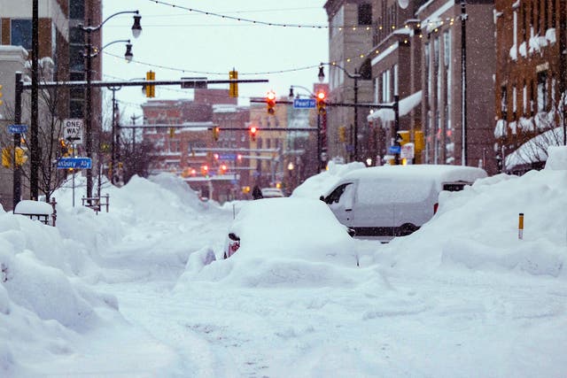 <p>Vehicles trapped under heavy snow in the streets of downtown Buffalo, New York, on 26 December, 2022</p>