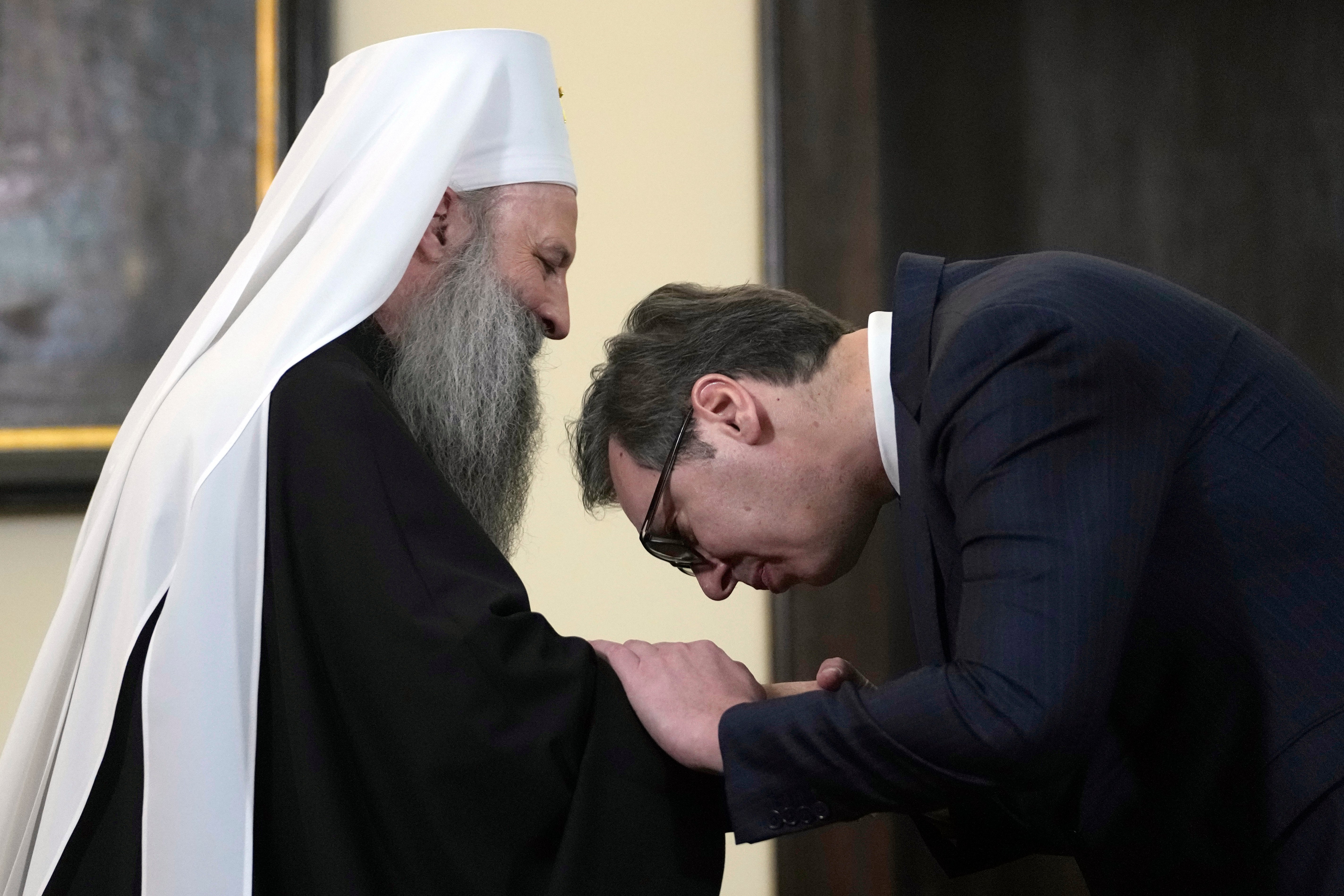 Serbian president Aleksandar Vucic kisses the hand of Serbian Orthodox Church Patriarch Porfirije on Tuesday after a news conference in Belgrade