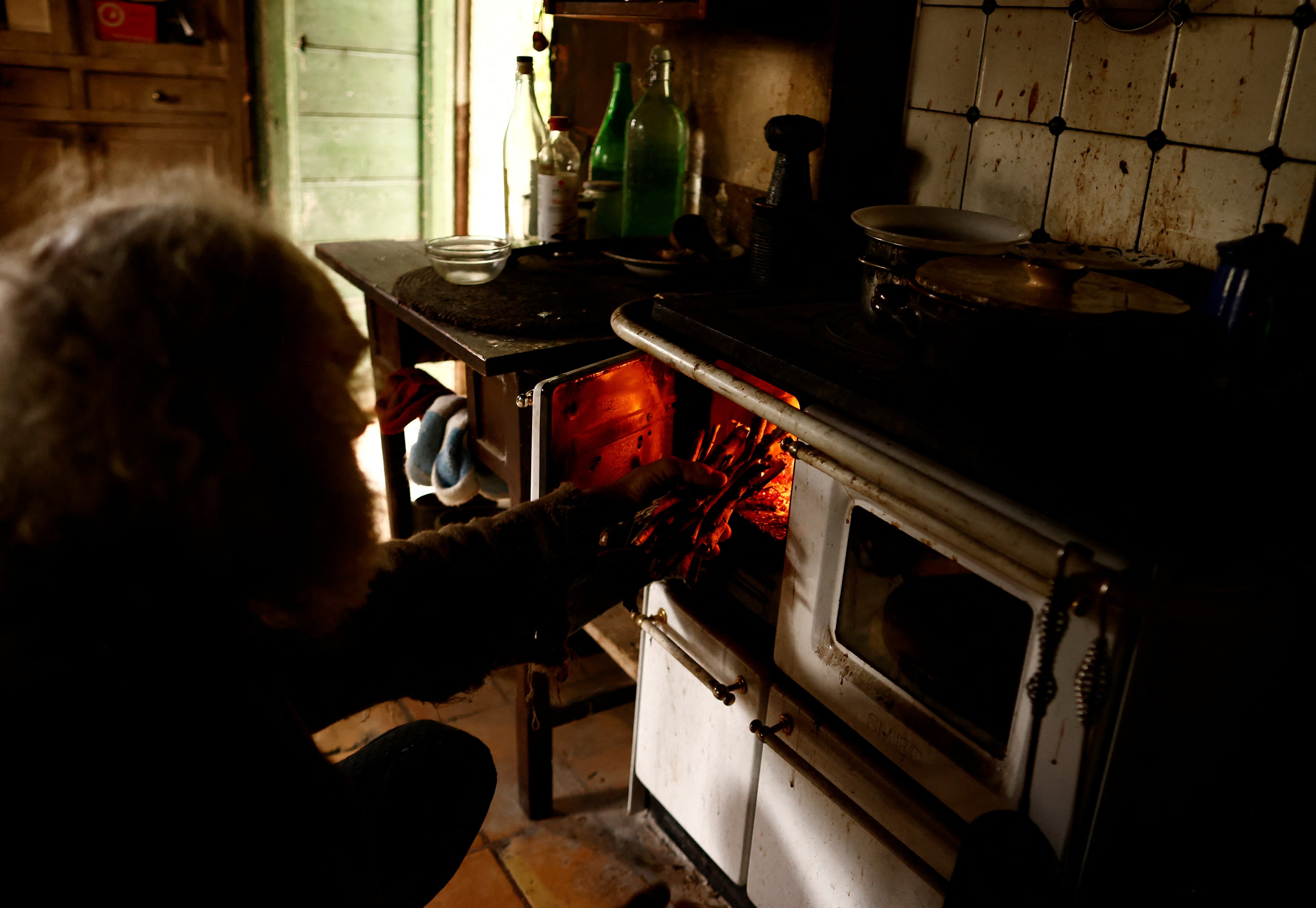 Fabrizio lights his wooden cooker at his home