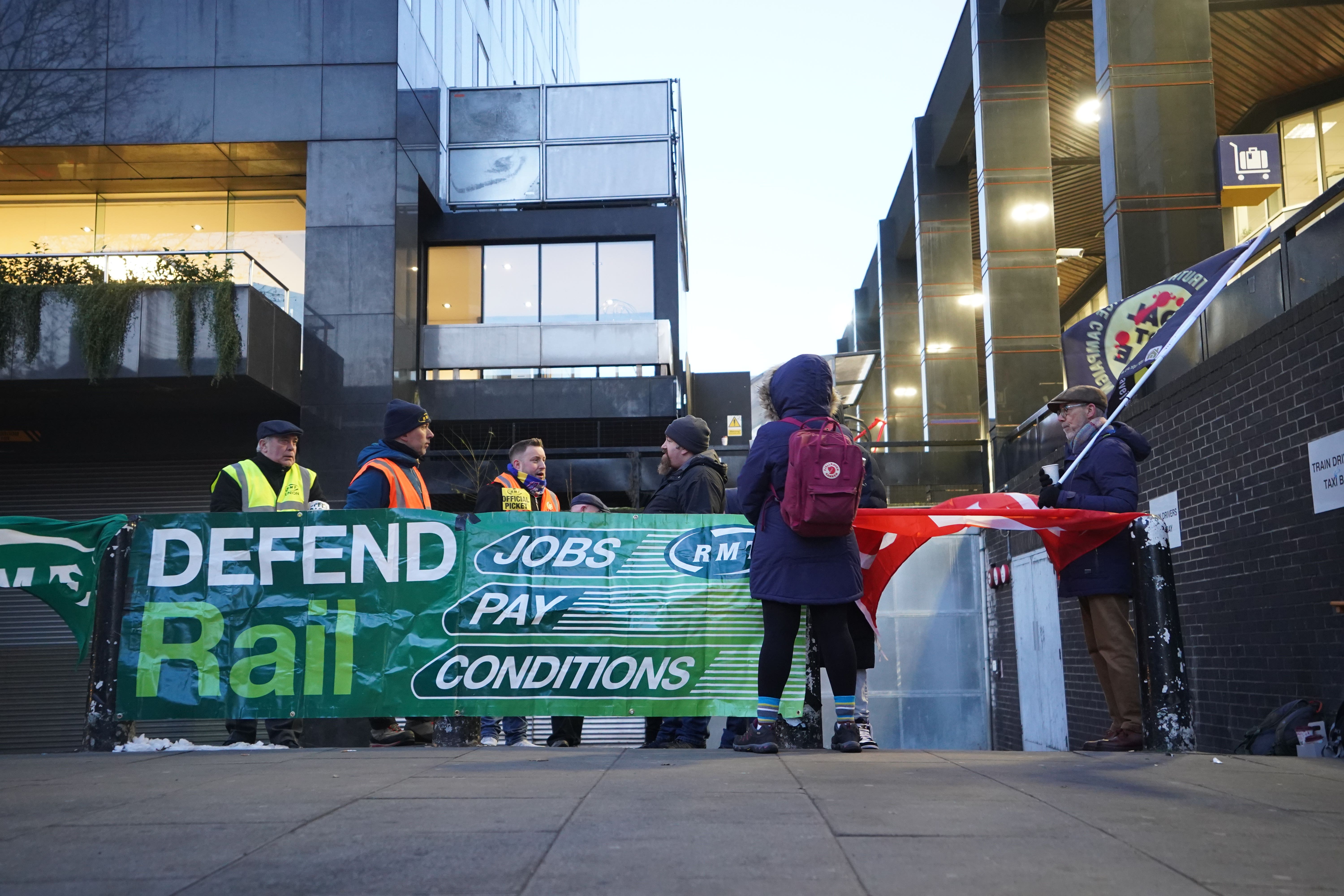 Members of the Rail, Maritime and Transport union (RMT) on the picket line outside London Euston train station (James Manning/PA)