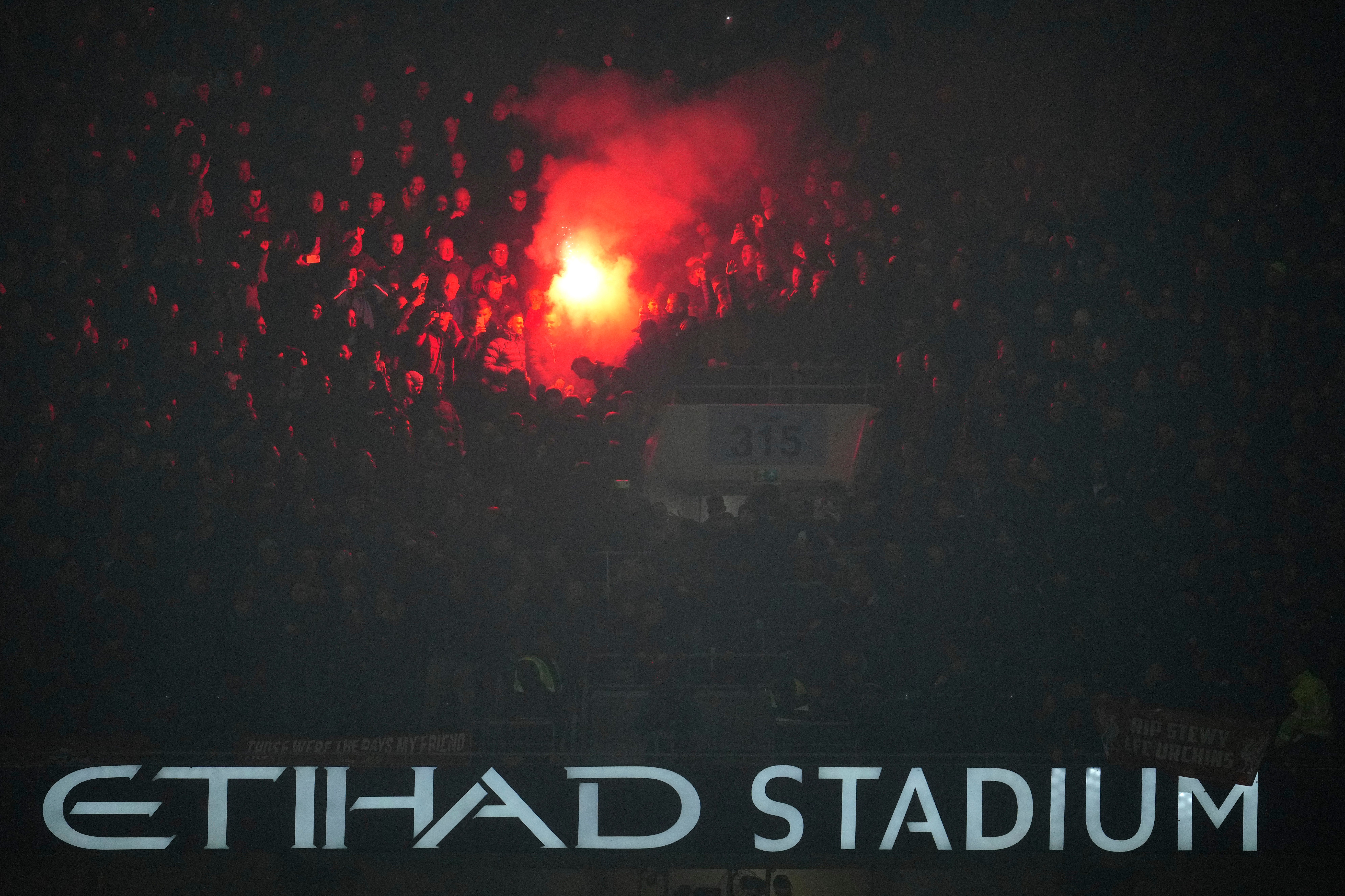 A flare goes off in the stands during Manchester City’s Carabao Cup tie with Liverpool