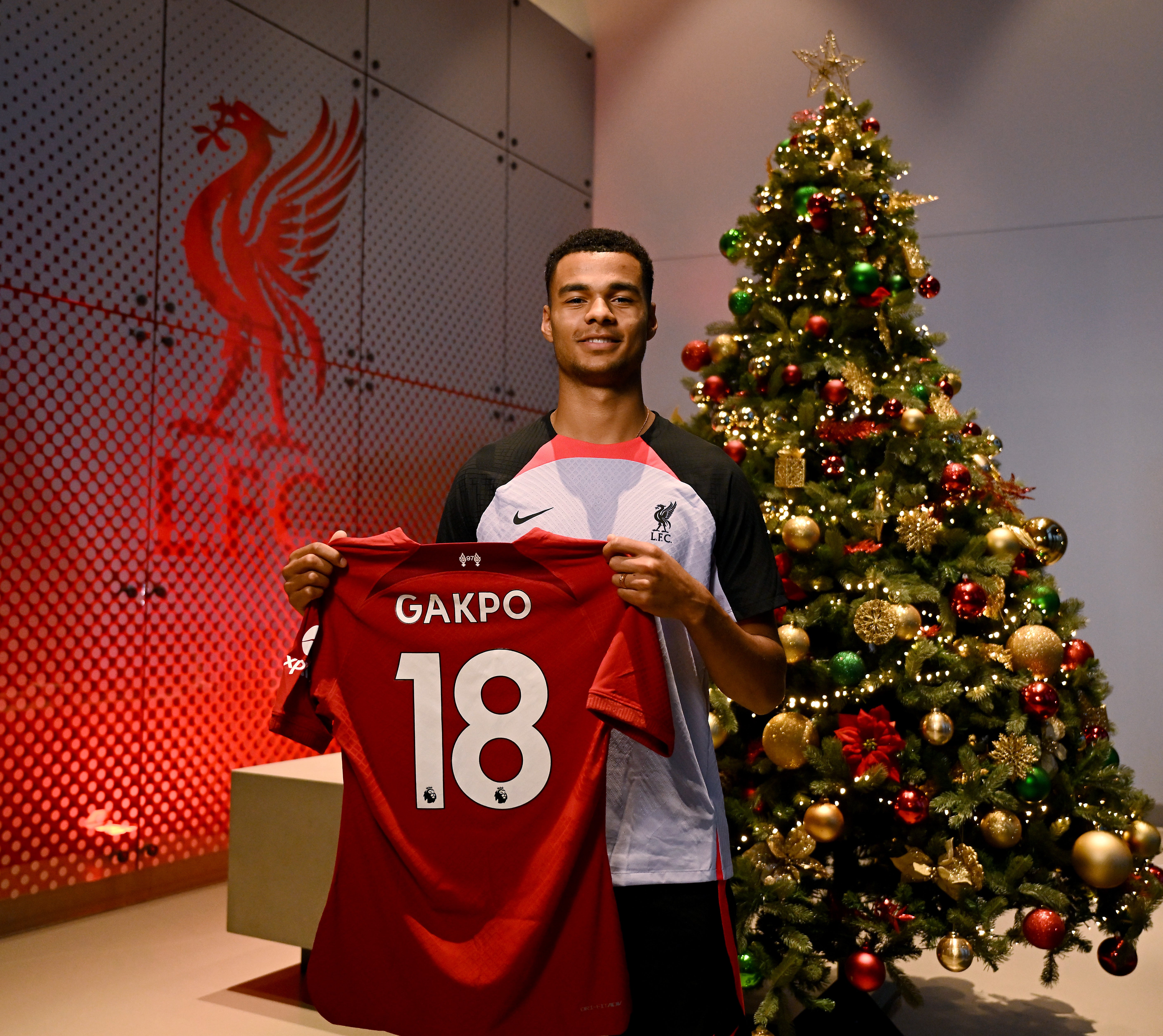 Cody Gakpo poses with the Liverpool shirt