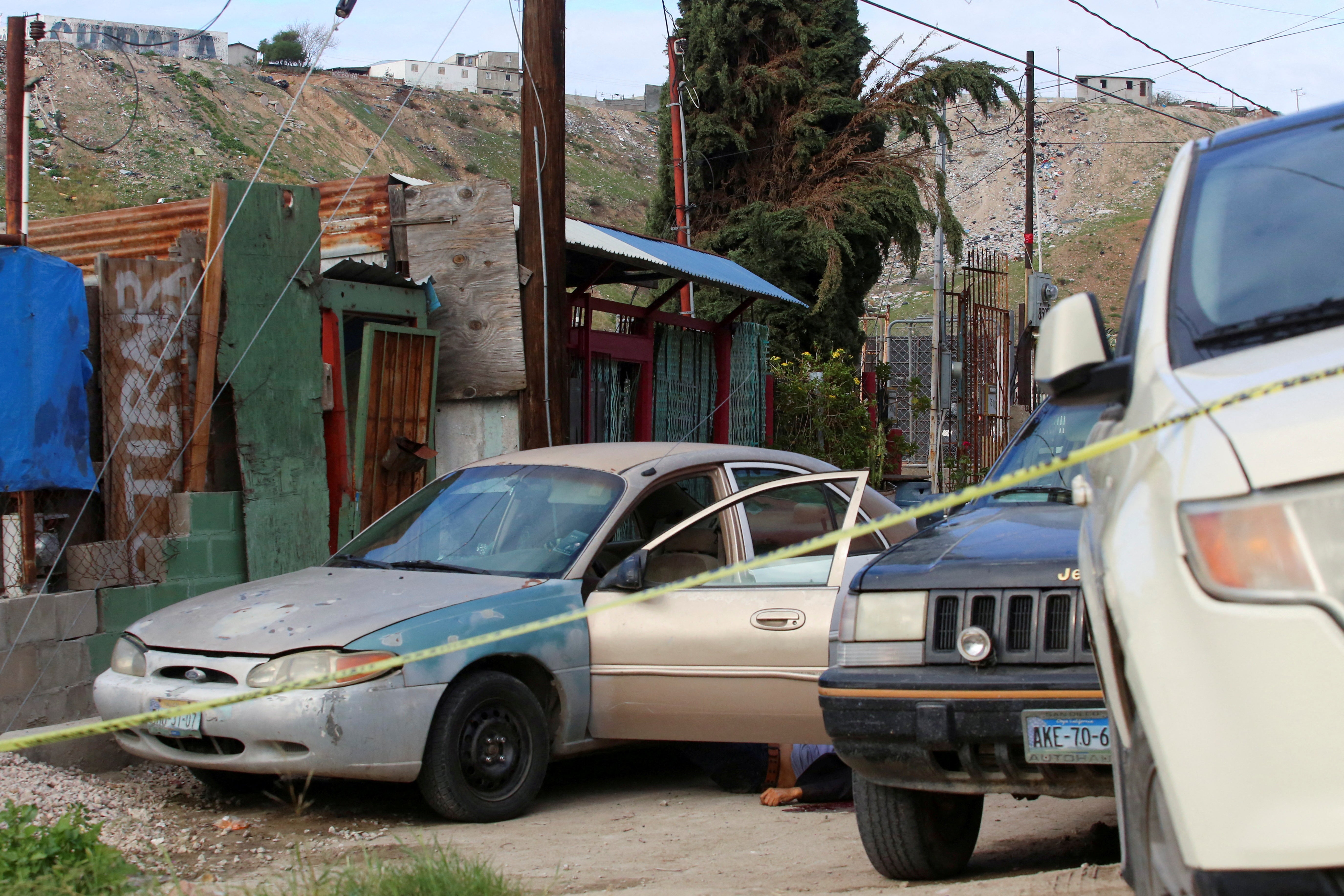 The body of Mexican photojournalist Margarito Martinez Esquivel lies on the ground next to his car after he was killed outside his home, in Tijuana, Mexico