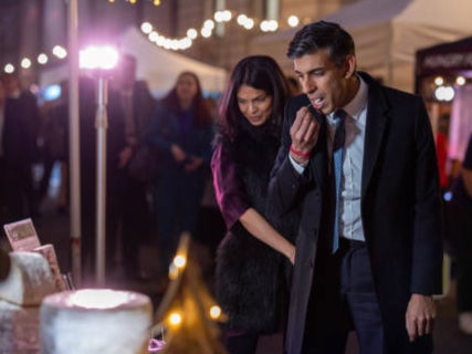 Mr Sunak and his wife Akshata Murty try different types of cheese at a Christmas Market in Downing Street