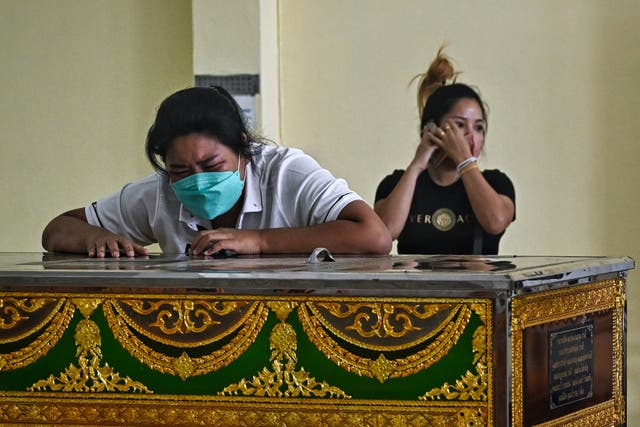 <p>Relatives of a victim of the Grand Diamond City hotel-casino fire in Poipet, Cambodia, mourn at a temple on the Thai side of the border in Aranyaprathet</p>