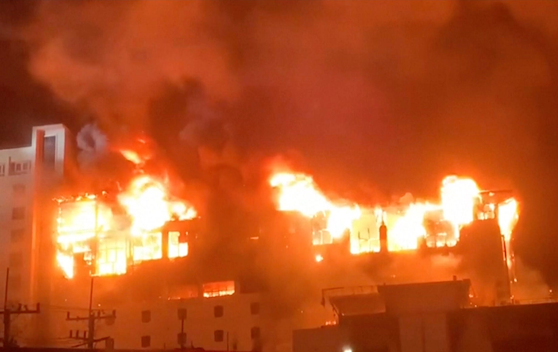 In this image from video provided by Fresh News, fire engulfs part of the Grand Diamond City casino and hotel in the town of Poipet