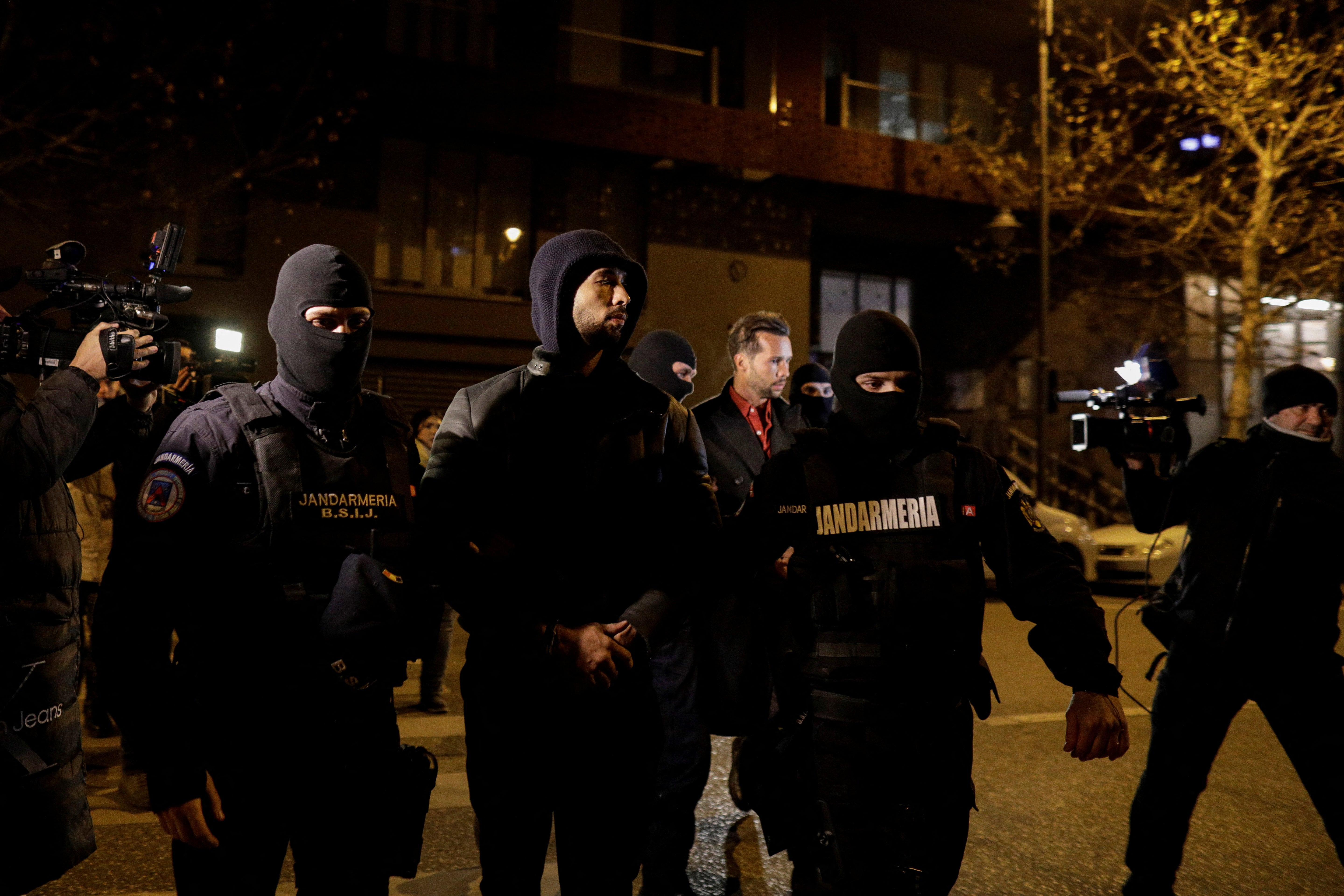 Andrew and Tristan Tate are escorted by police officers outside the headquarters of the Directorate for Investigating Organized Crime and Terrorism in Bucharest