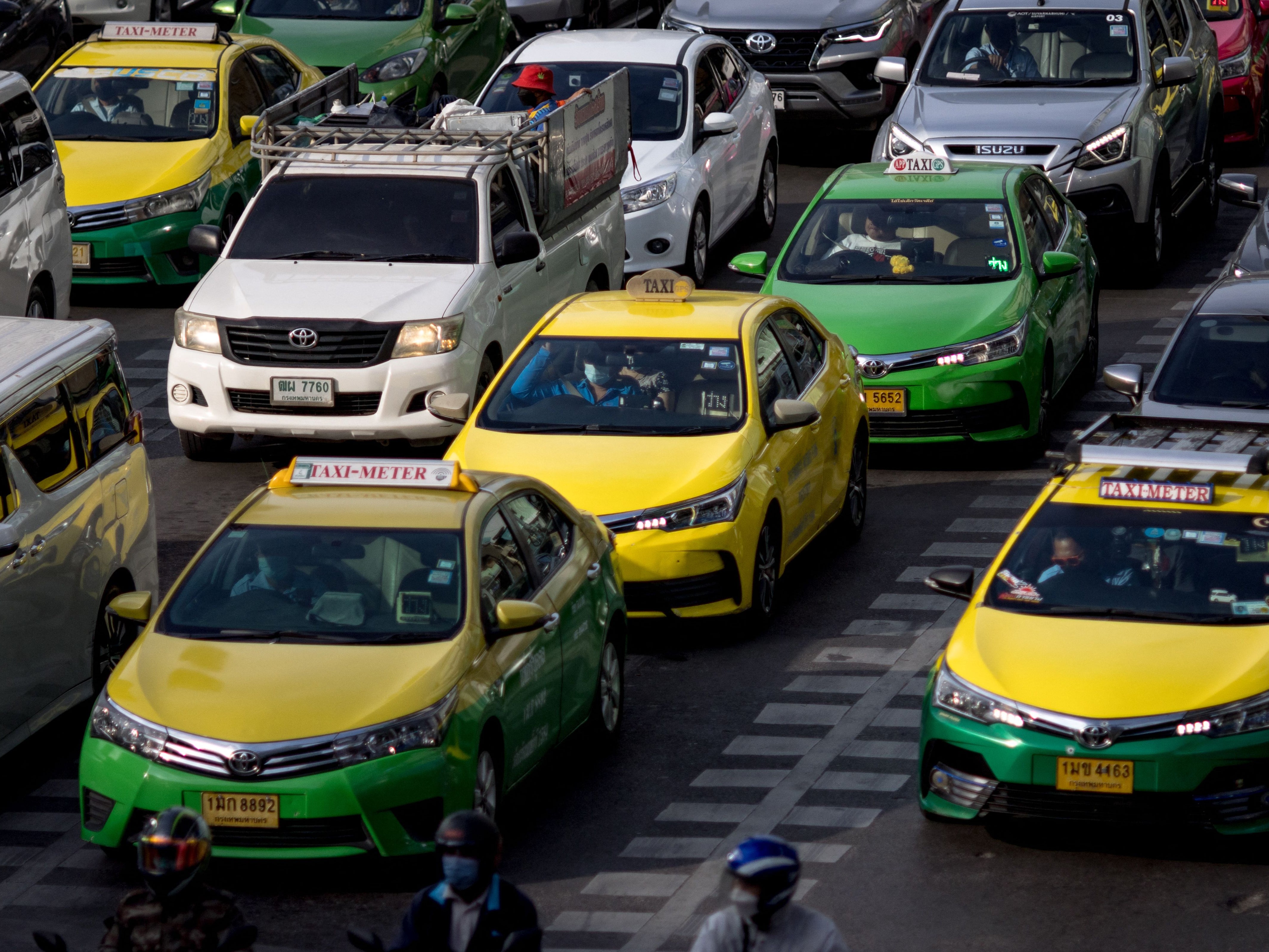 File. Taxis wait at a red light signal on a street in Bangkok on 10 November 2022