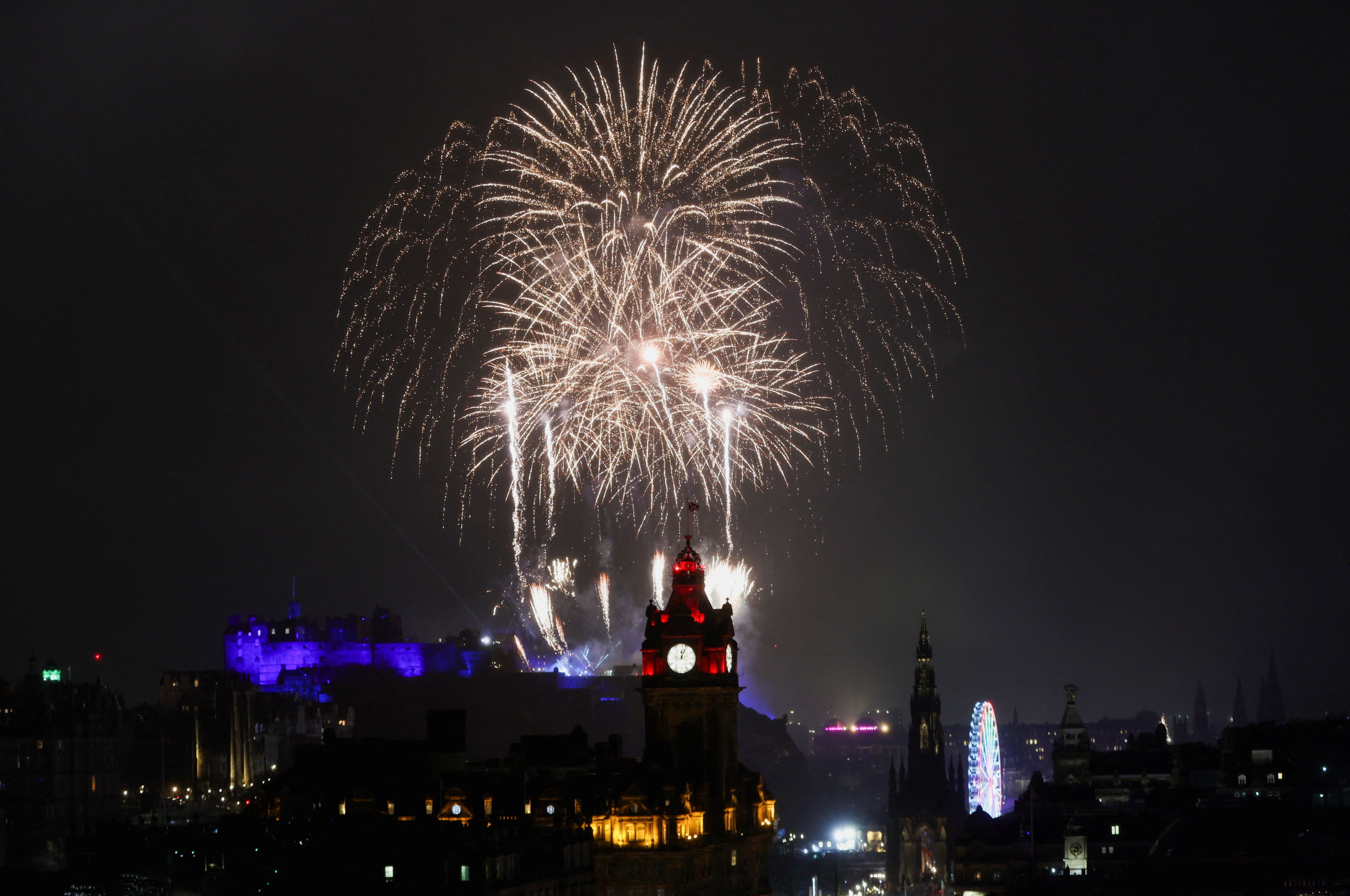 Fireworks light up the sky over Edinburgh Castle and the Balmoral Hotel Clock for Hogmanay