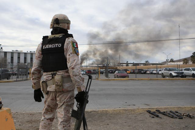 <p>A Mexican solider stands guard at a prison in Ciudad Juarez after dozens of inmates escaped on 1 January </p>