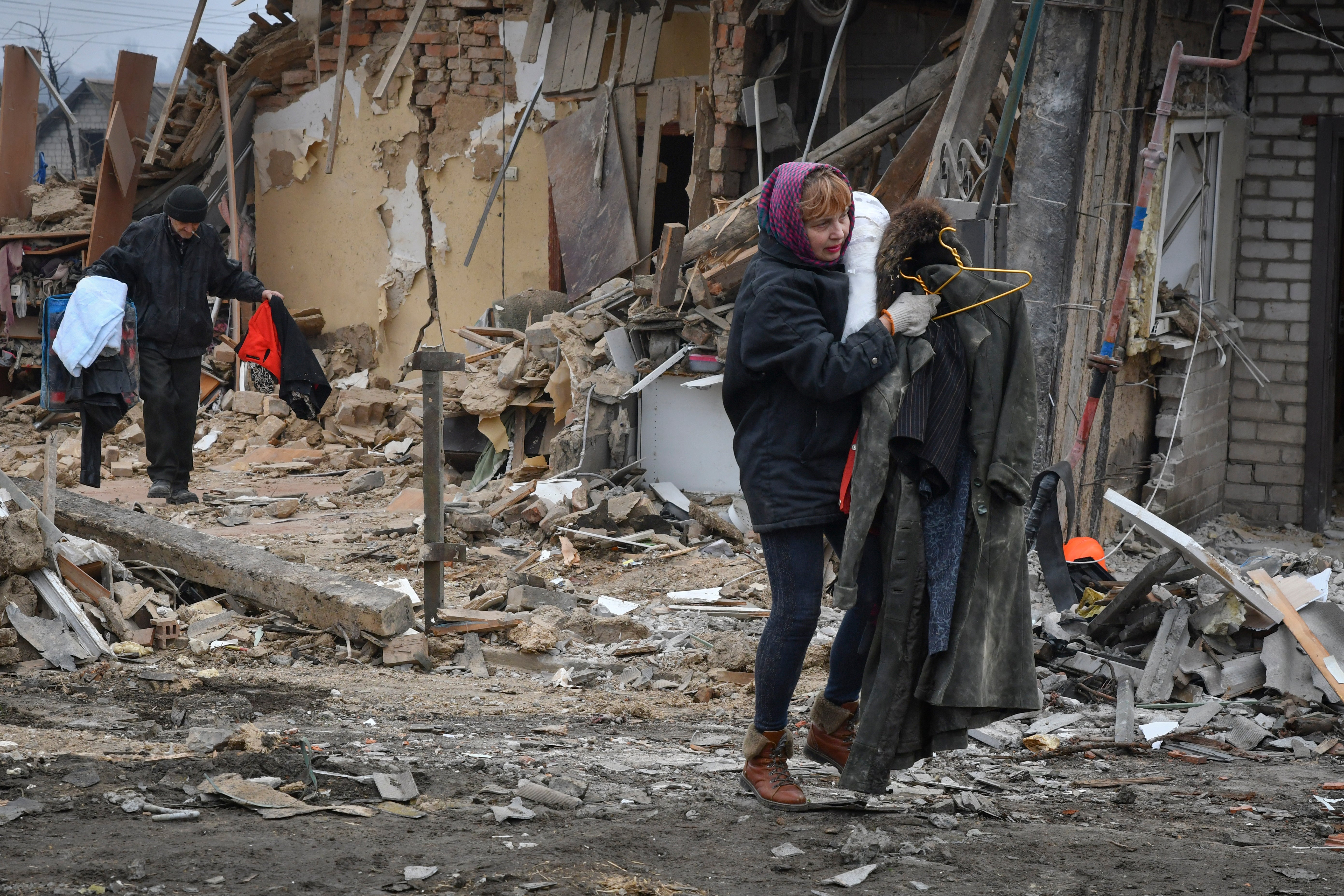 Zaporizhzhia residents carry their belongings as they leave homes devastated in Saturday’s rocket attacks