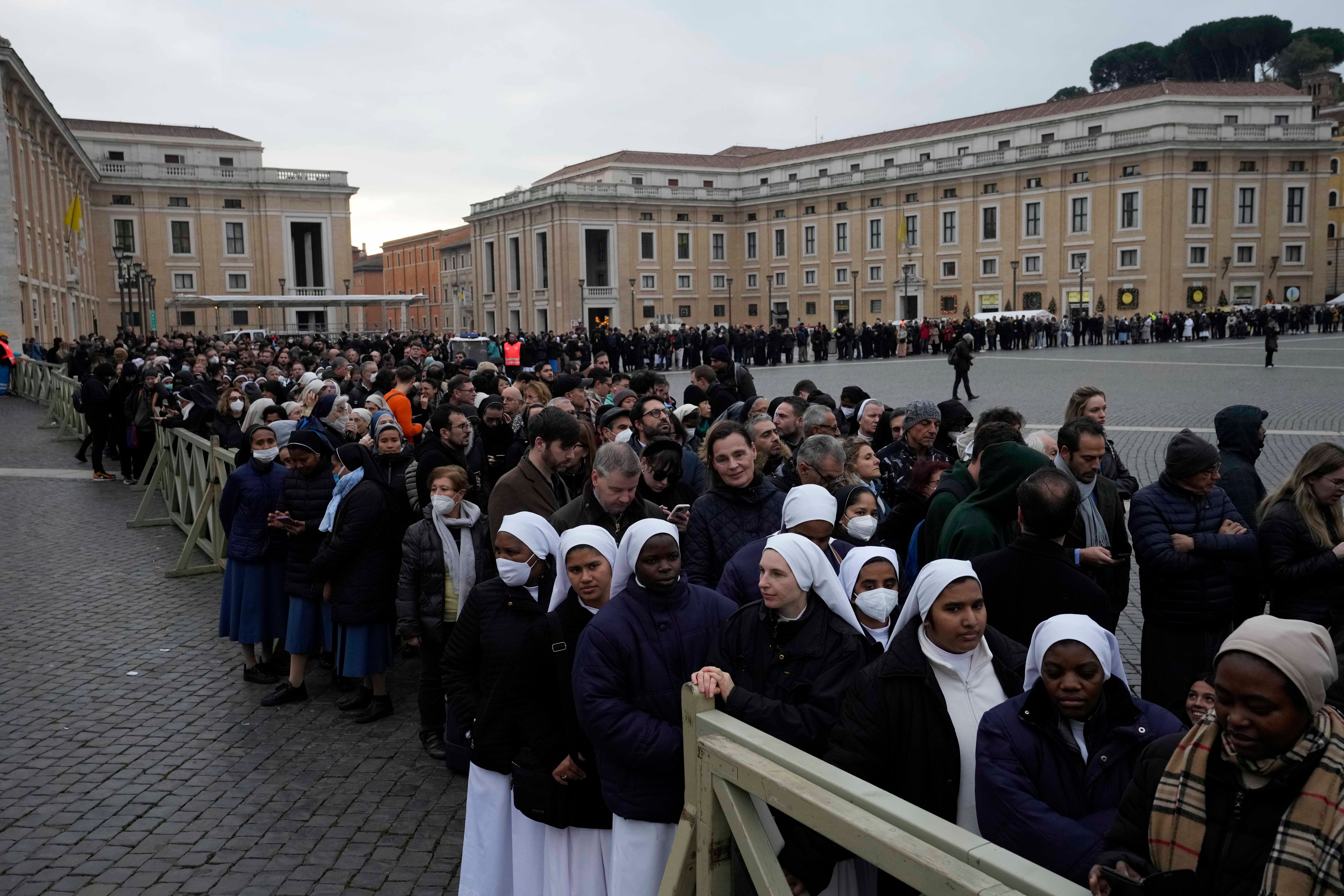 People wait in a line to enter Saint Peter's Basilica at the Vatican