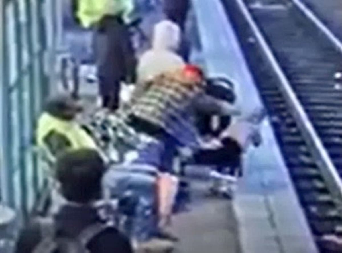 Horrifying moment woman pushes three-year-old onto train tracks