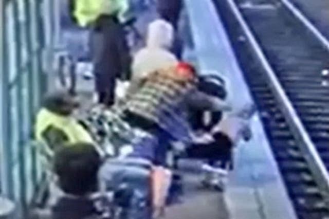<p>Footage captures moment a woman shoved a small child onto train tracks</p>