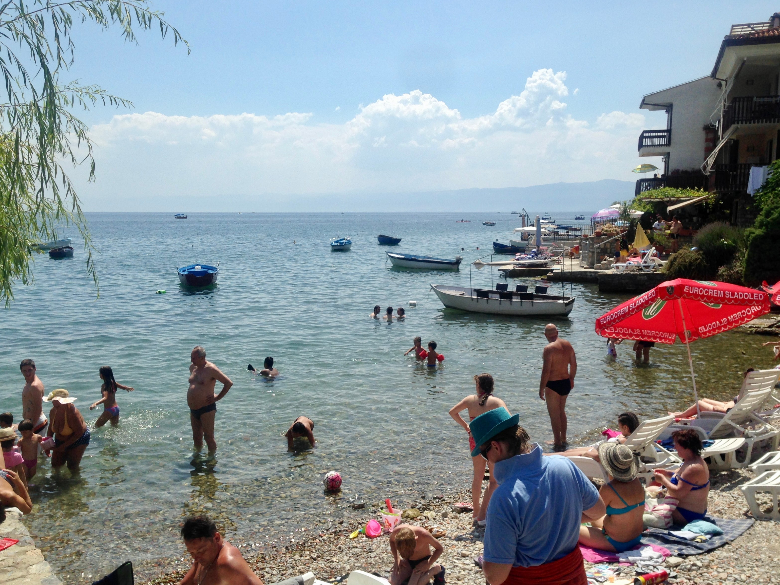 Holidaymakers at Ohrid in North Macedonia with the hills of Albania in the distance