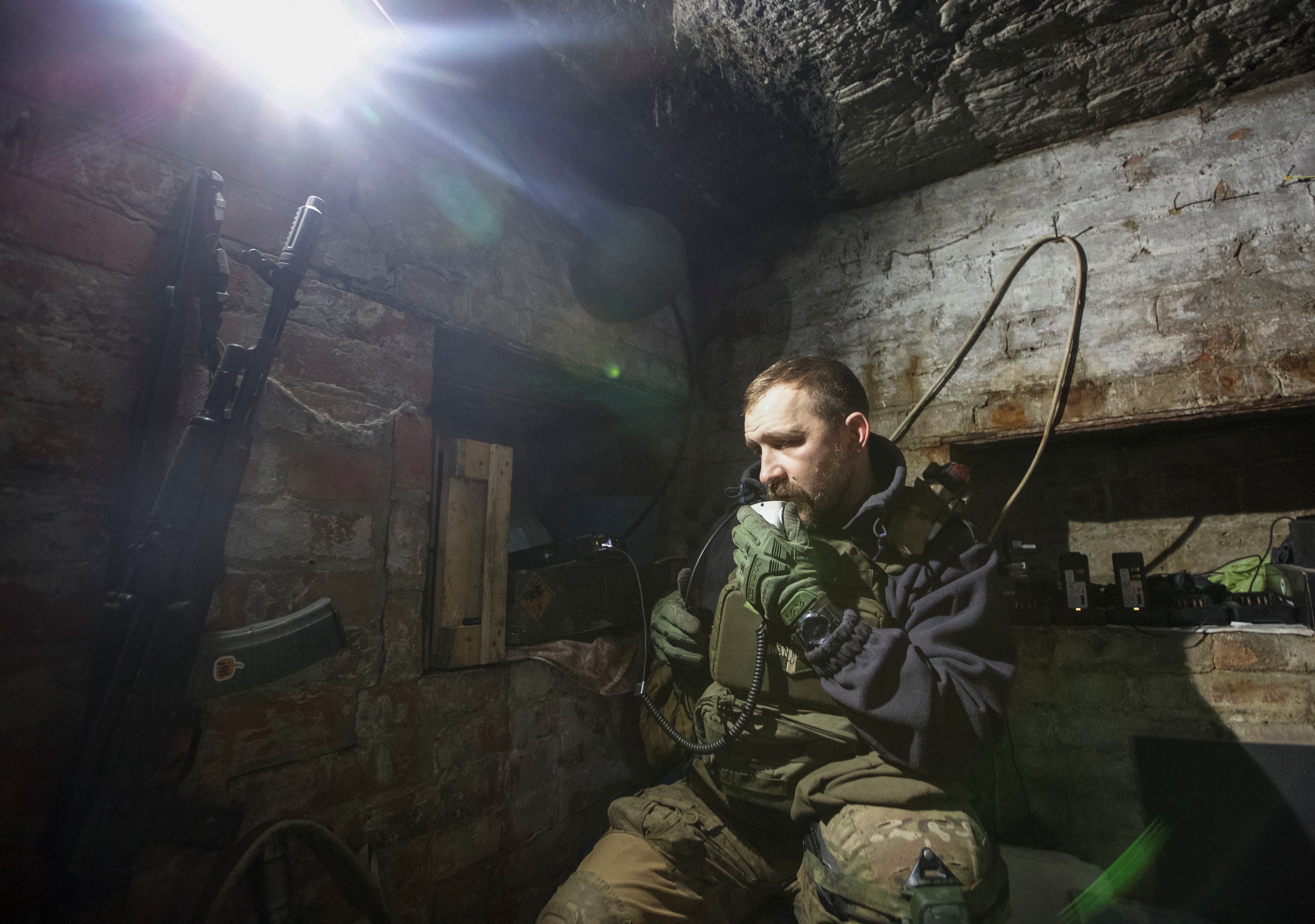 A Ukrainian service member uses a radio station in a shelter on a frontline in Bakhmut, Donetsk