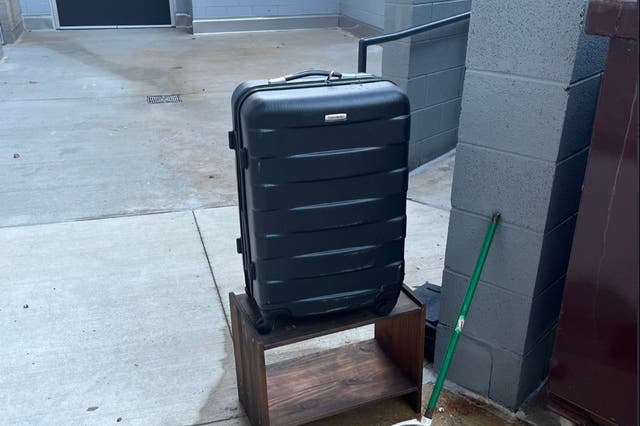 <p>Valerie Szybala’s suitcase pictured next to a dumpster</p>