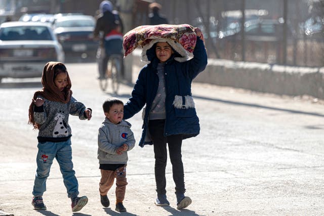 <p>Afghan children walk along a street in Kabul on 3 January 2023</p>