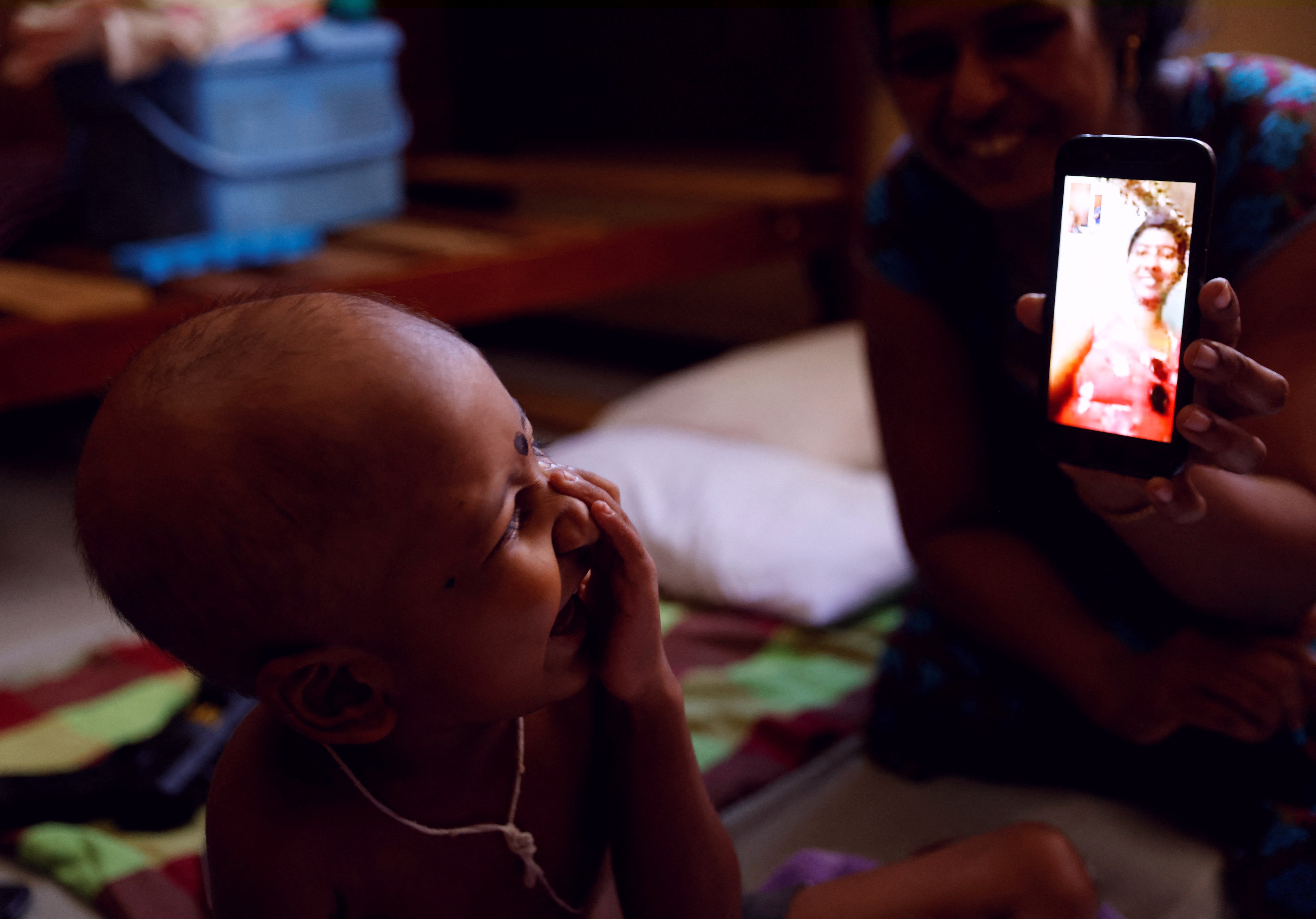 S Saksan laughs as he talks with his mother on a video call