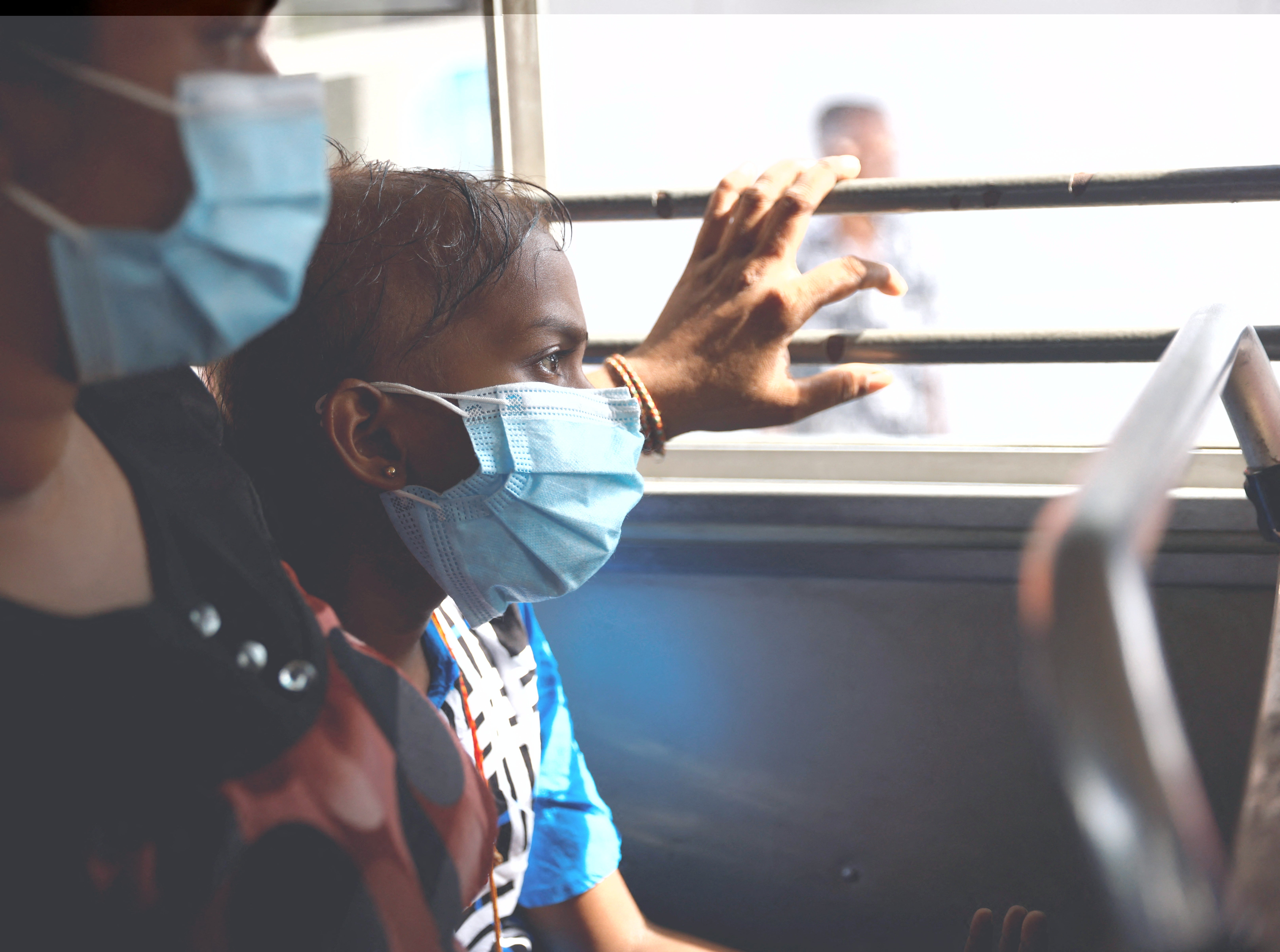 Sudhagaran Sadurshana, 9, who has acute myeloid leukaemia, rides a bus home with her mother Sudhagaran Punawadee after being discharged from Apeksha Hospital