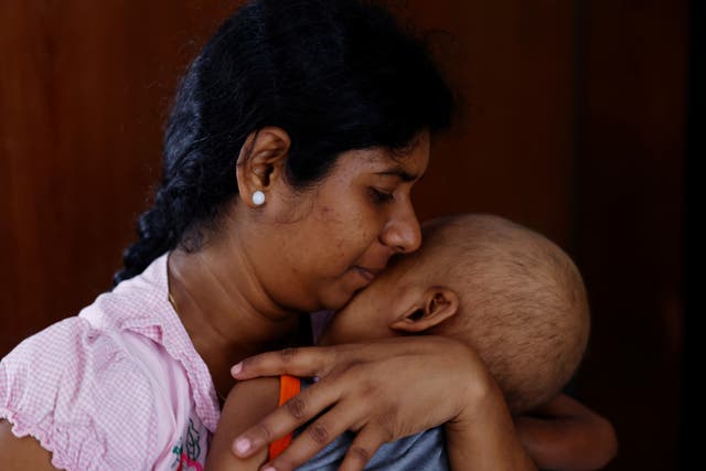 <p>Sathiyaraj Silaksana holds her five-year-old son S Saksan, who has leukaemia</p>