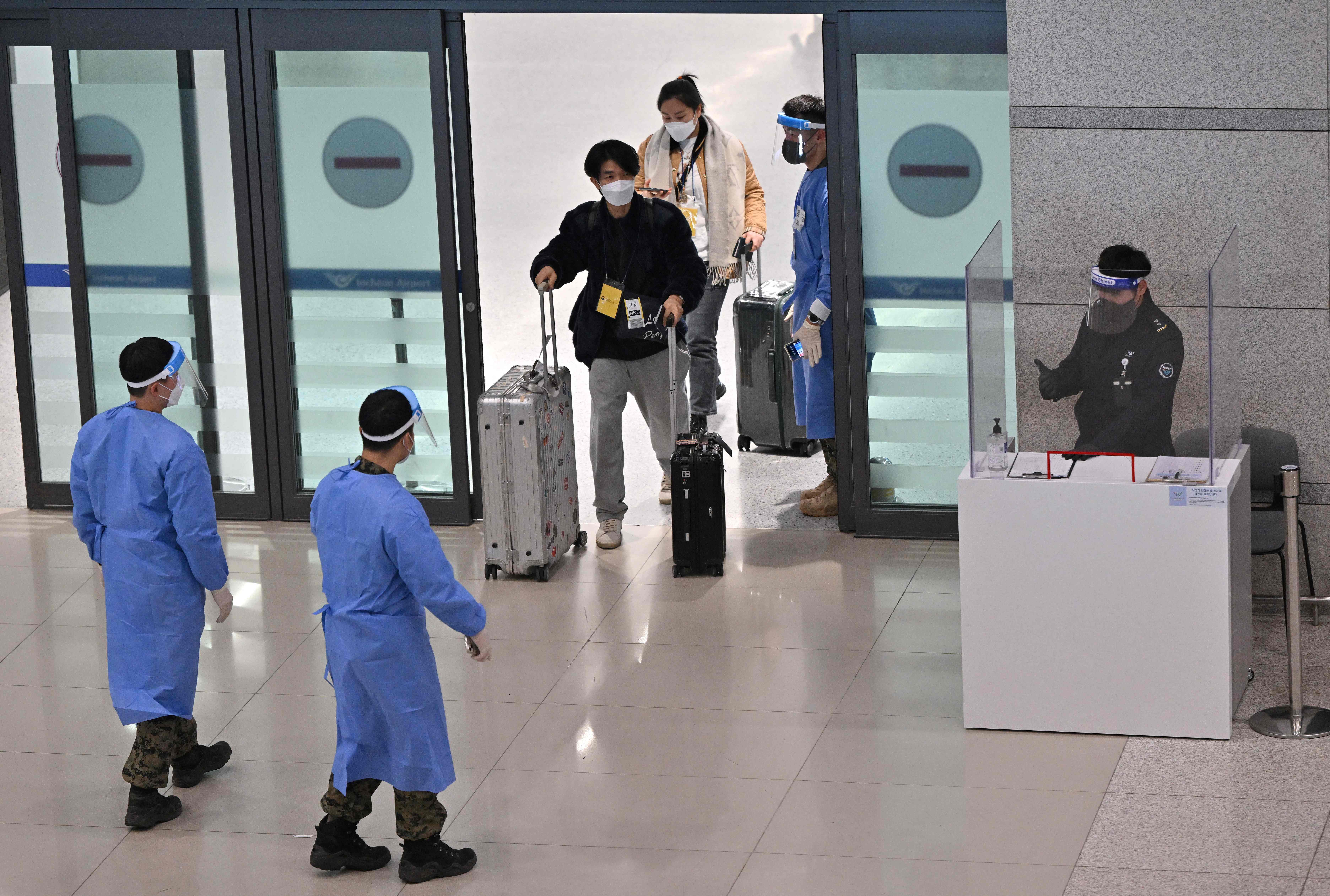 Health workers guide travellers arriving from China to a Covid-19 testing centre at South Korea’s Incheon International Airport, west of Seoul