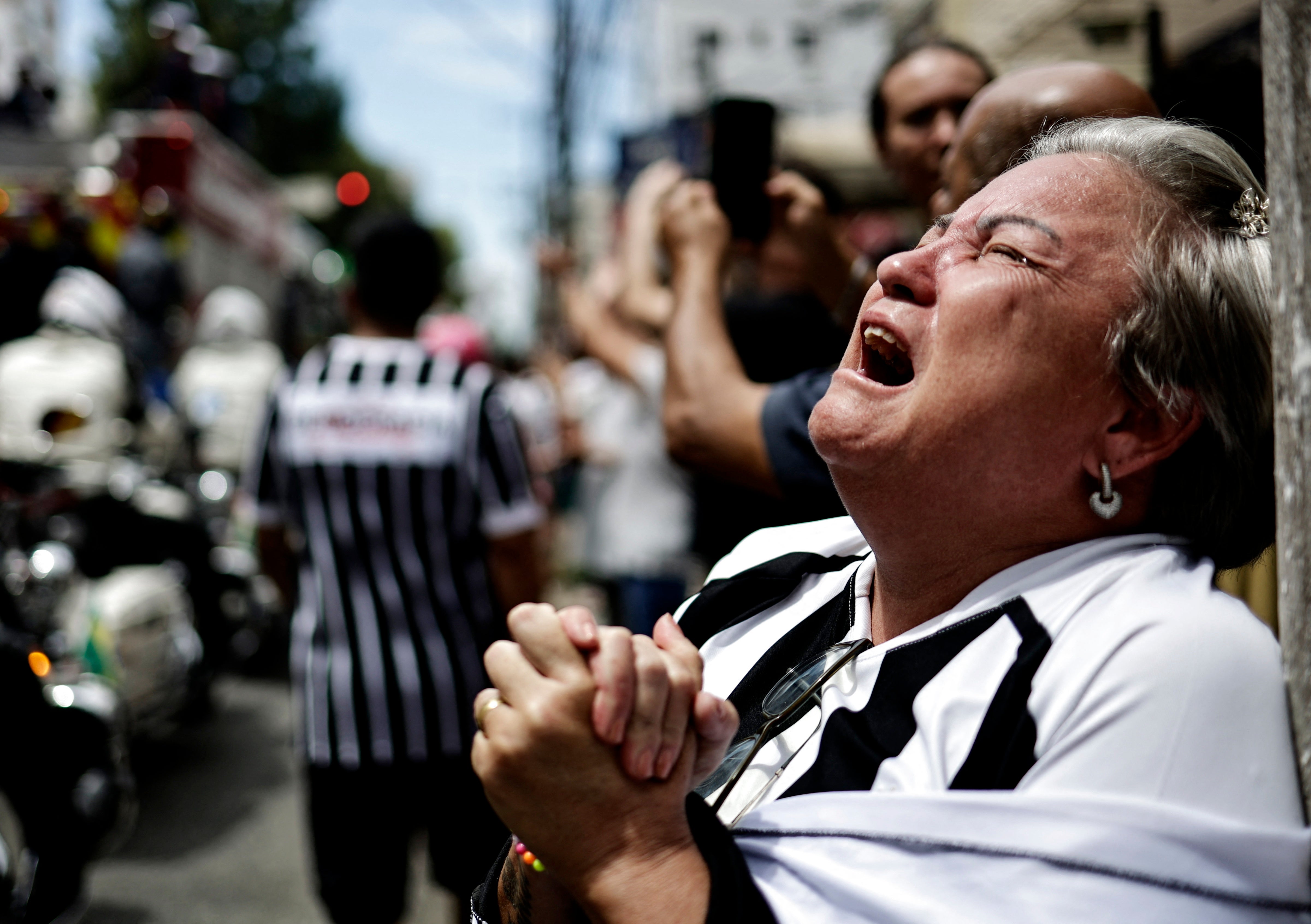 An emotional fan reacts during the procession of Pelé’s casket