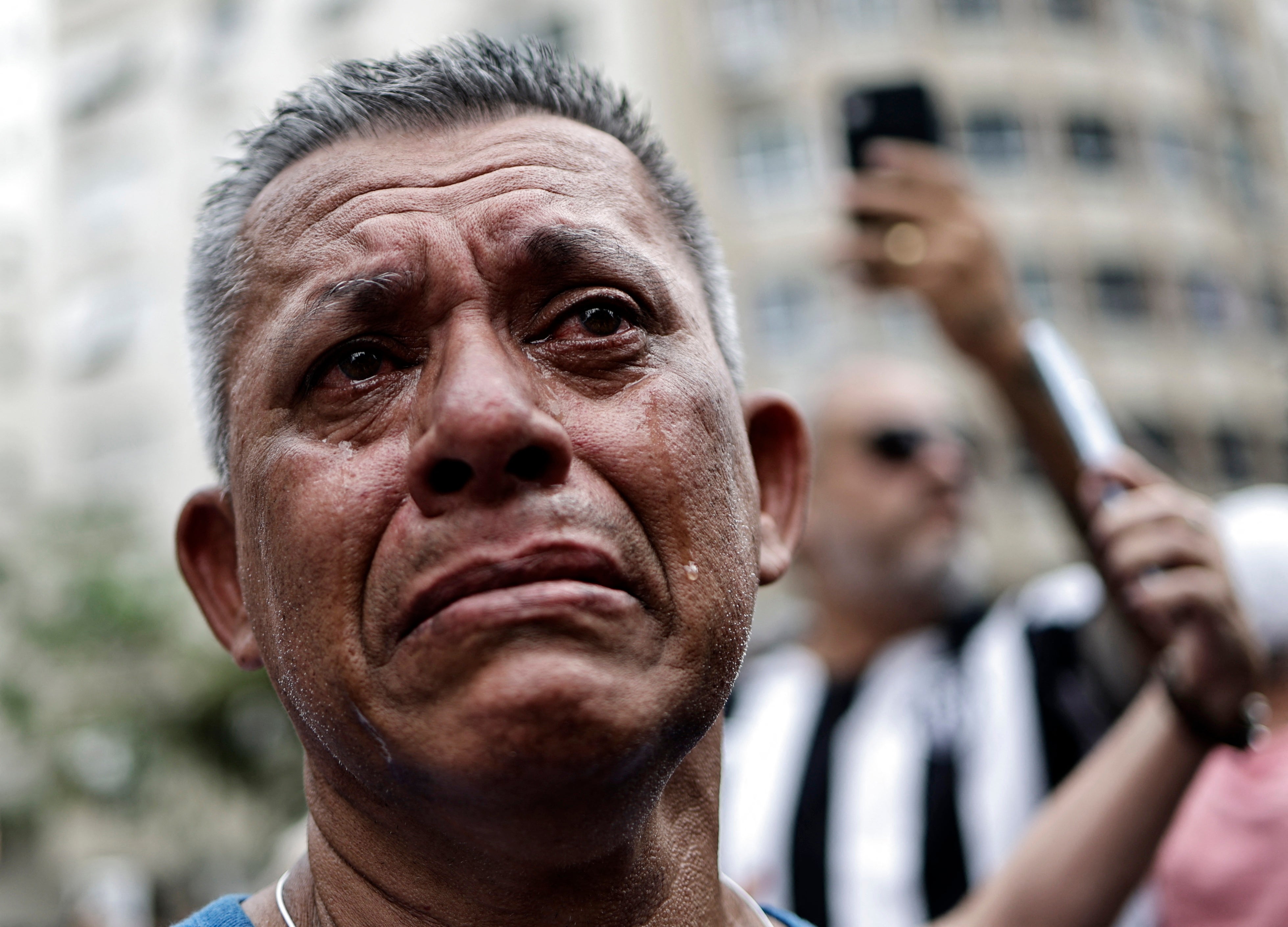 A fan reacts emotionally as Pelé’s casket passes by in Santos