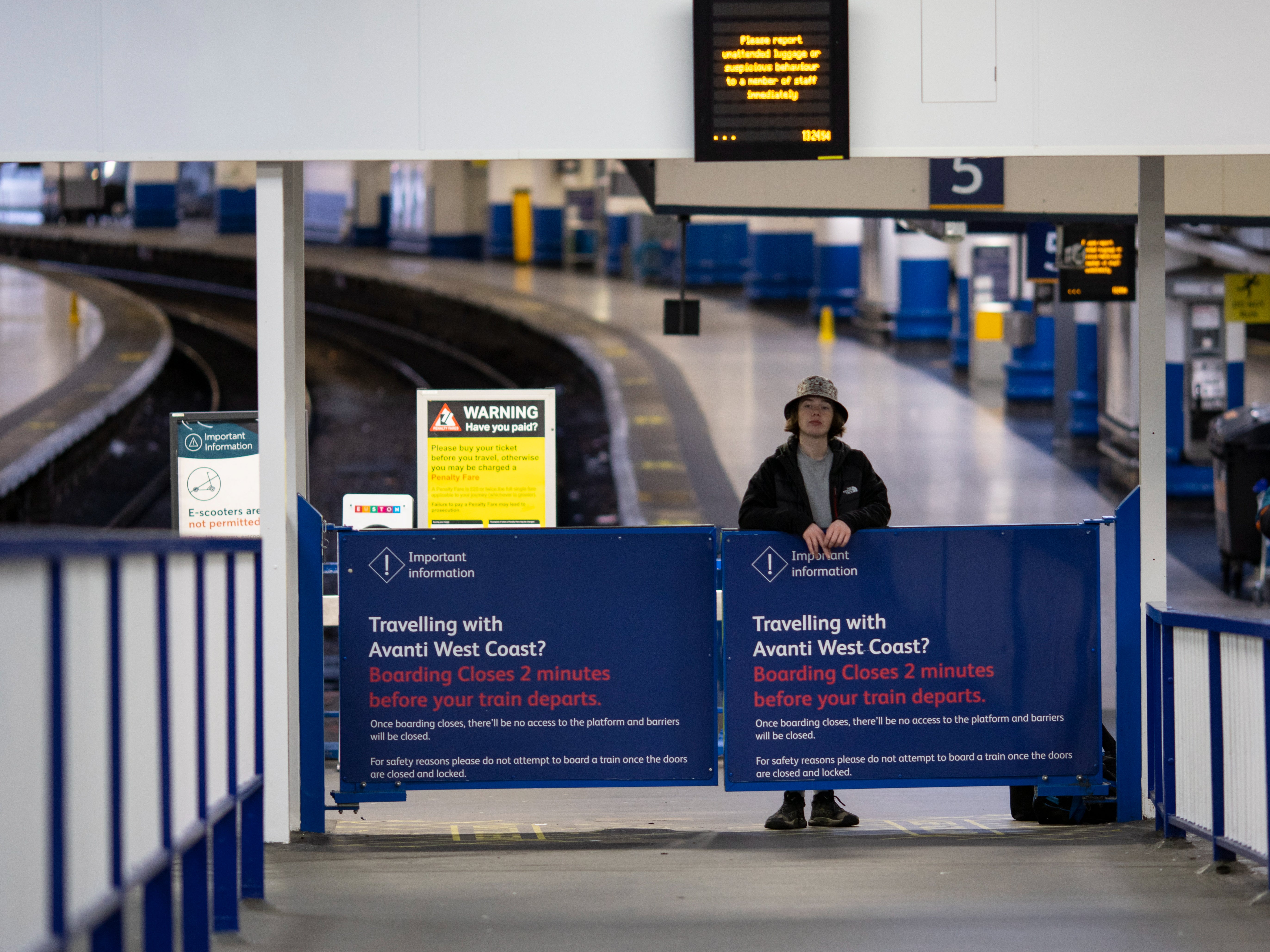 A passenger waits for a train at Euston Station in London, Britain