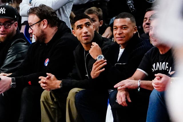 <p>Kylian Mbappe, right, alongside PSG teammate Achraf Hakimi at an NBA game in New York on Monday</p>