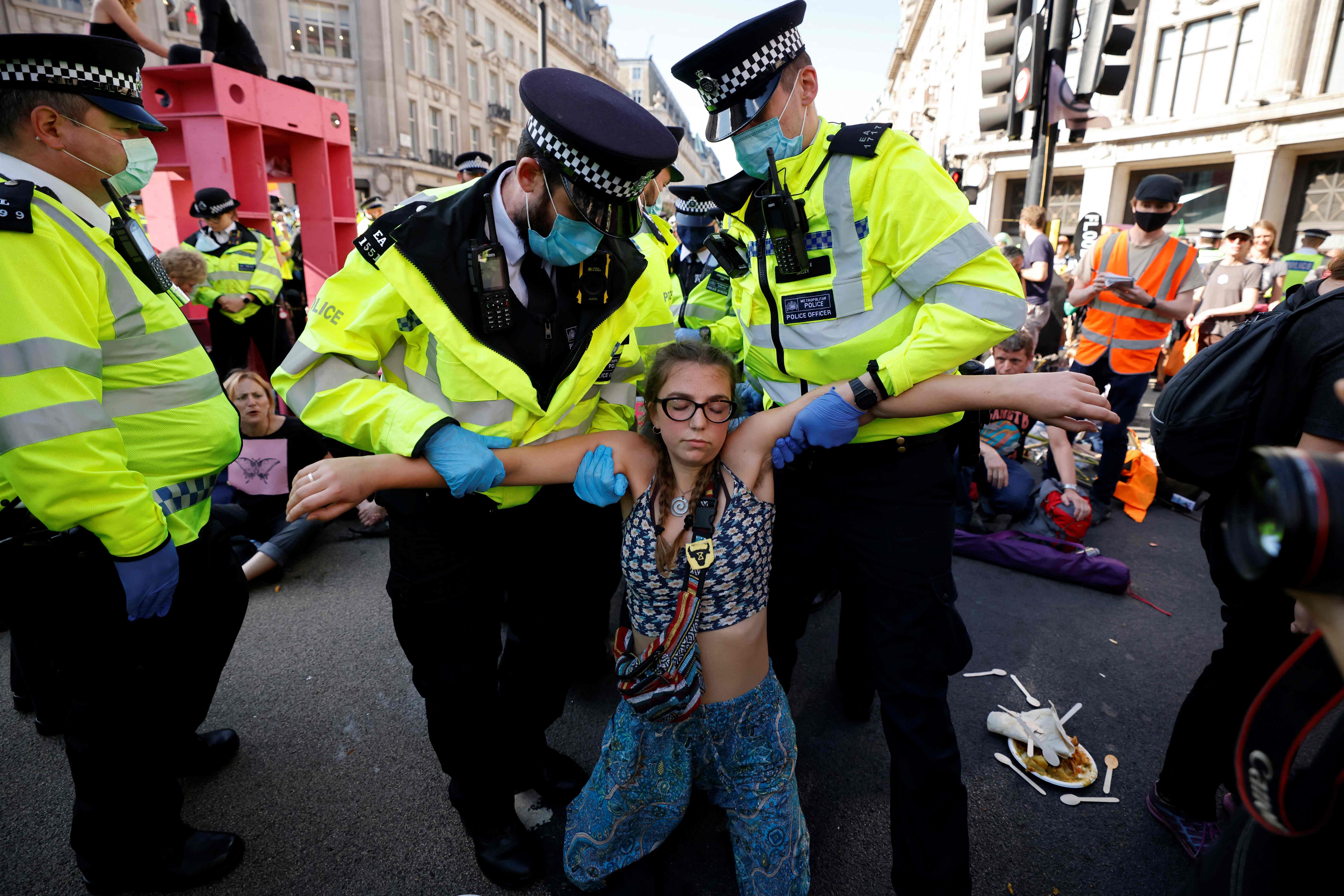 Police officers carry an Extinction Rebellion activist during a series of actions in central London. in August 2021 . The group said it would shift tactics in early 2023