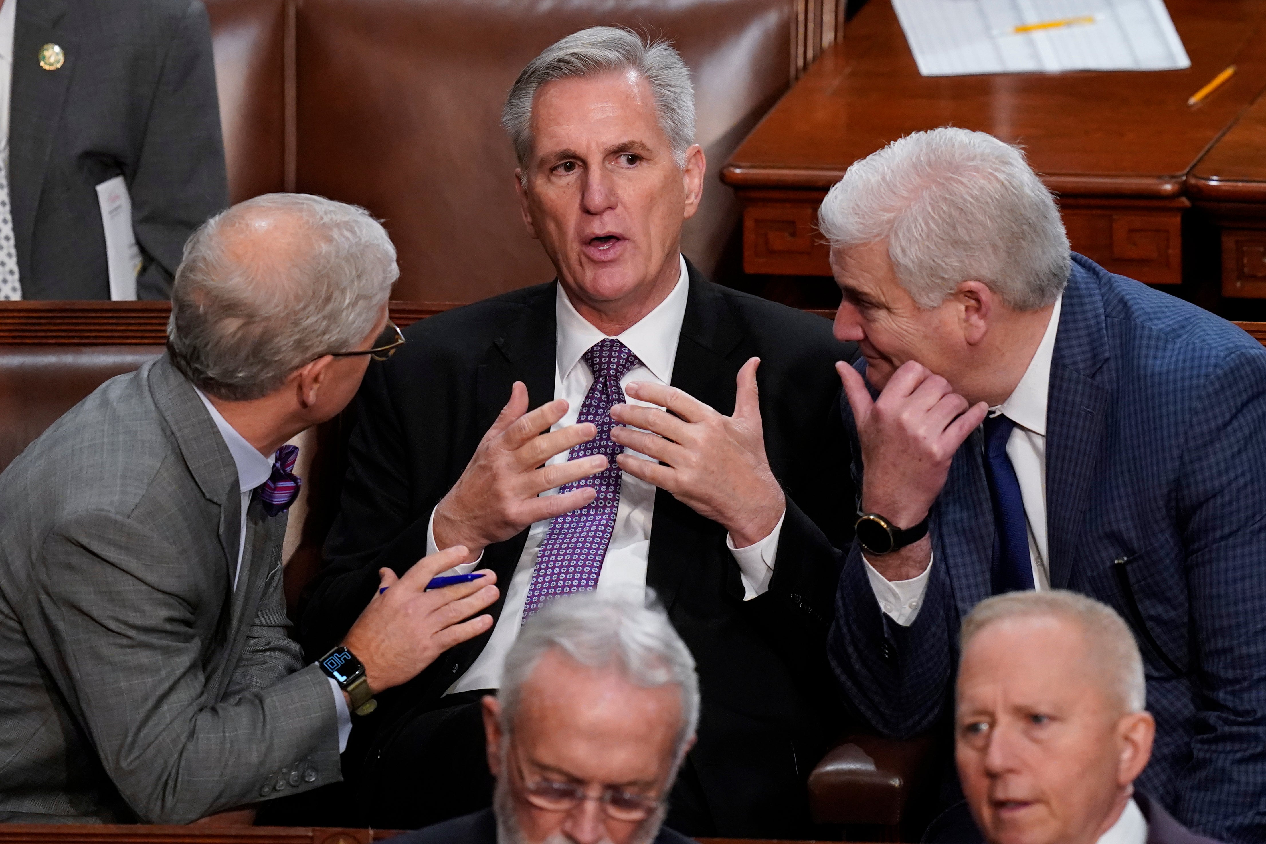 Rep Patrick McHenry and Rep Tom Emmer speak with Rep Kevin McCarthy in a pose reminiscent of a renaissance painting