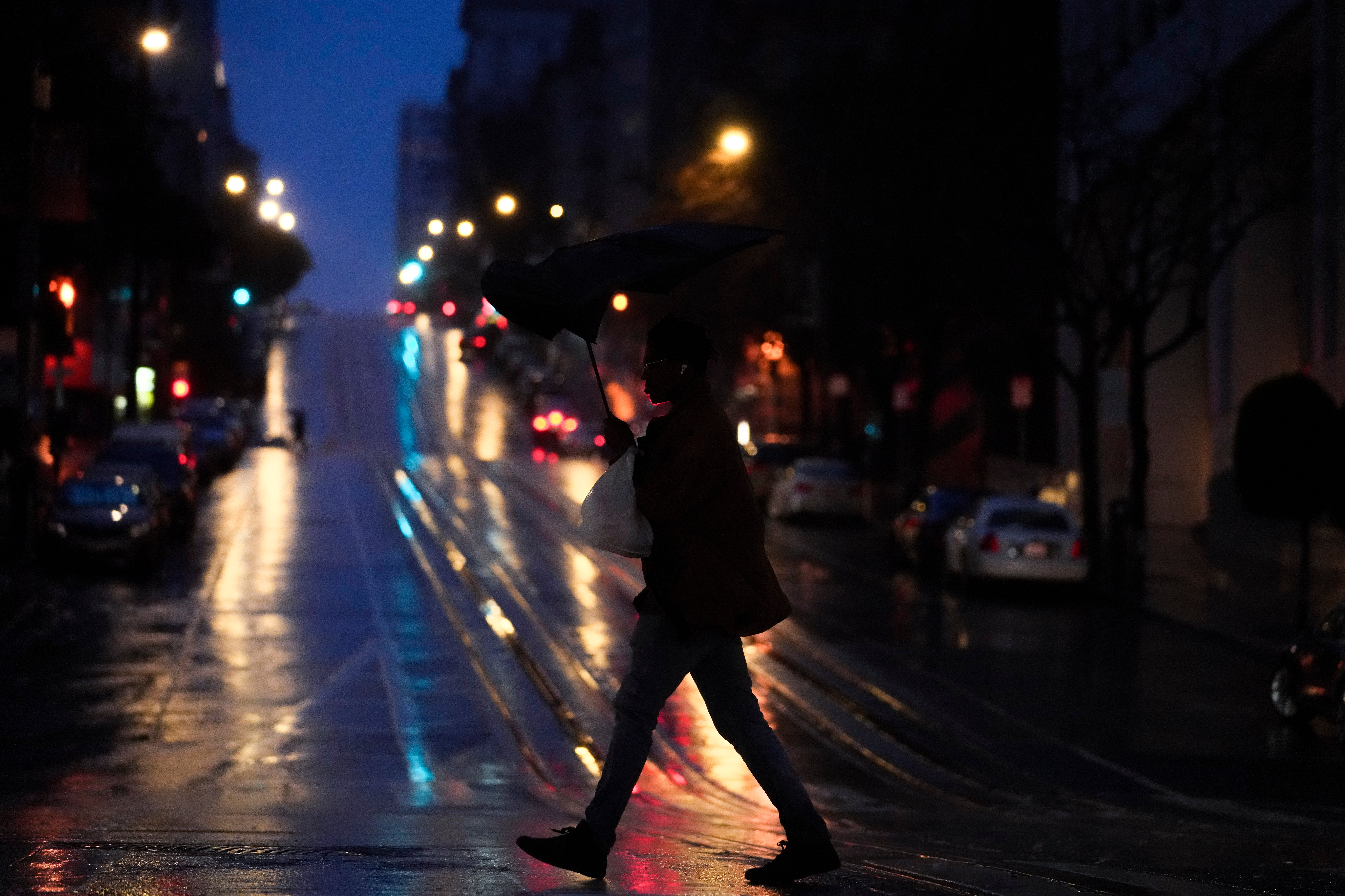 A person walks across California Street in San Francisco on Wednesday, Jan. 4, 2023. Another winter storm moved into California on Wednesday