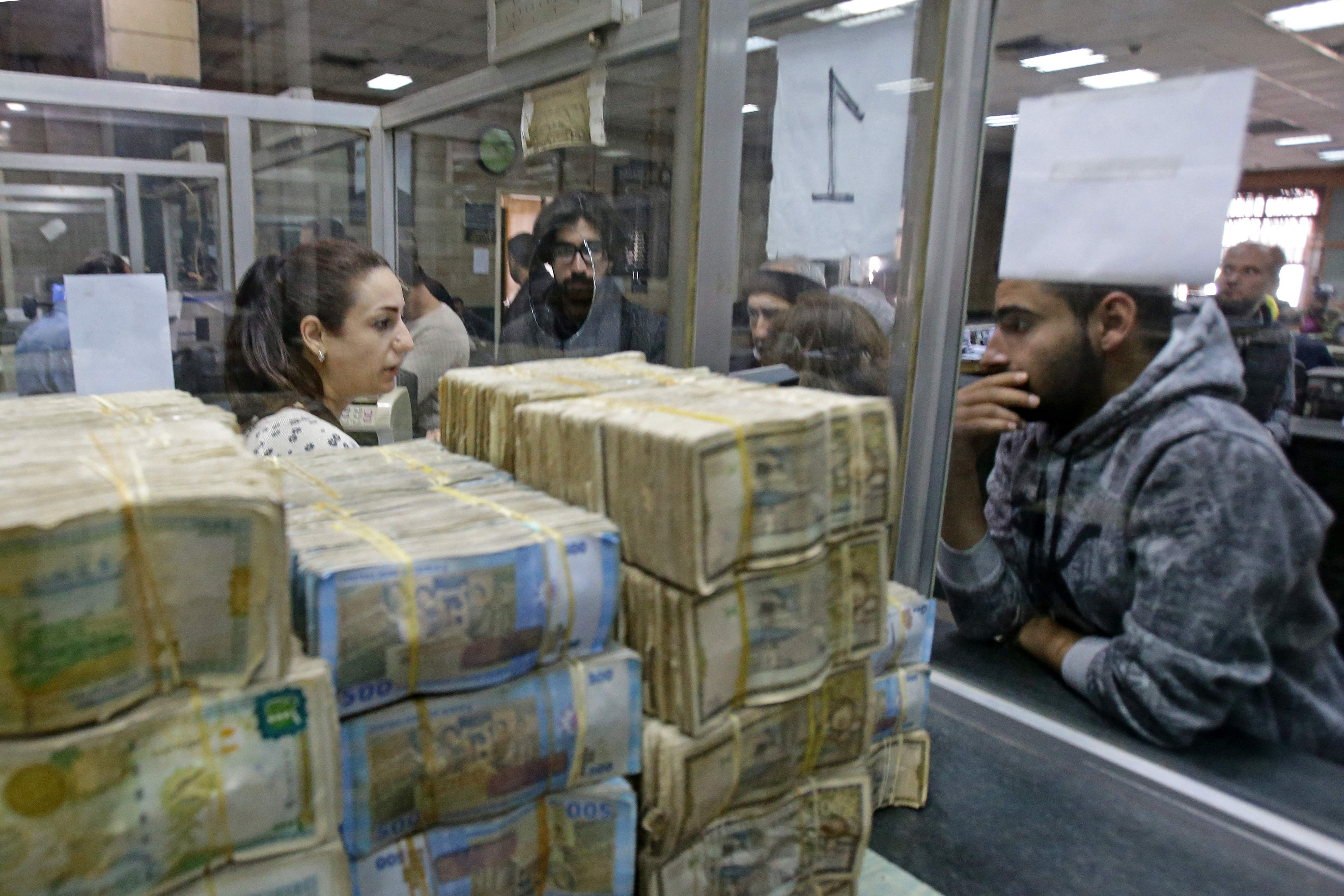 Syrians trying to withdraw money in Damascus in November amid growing economic pressure