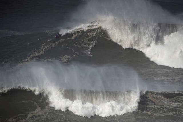 <p>A surfer rides a wave in Nazare, Portugal in February 2022. Marcio Freire died surfing there on Thursday</p>