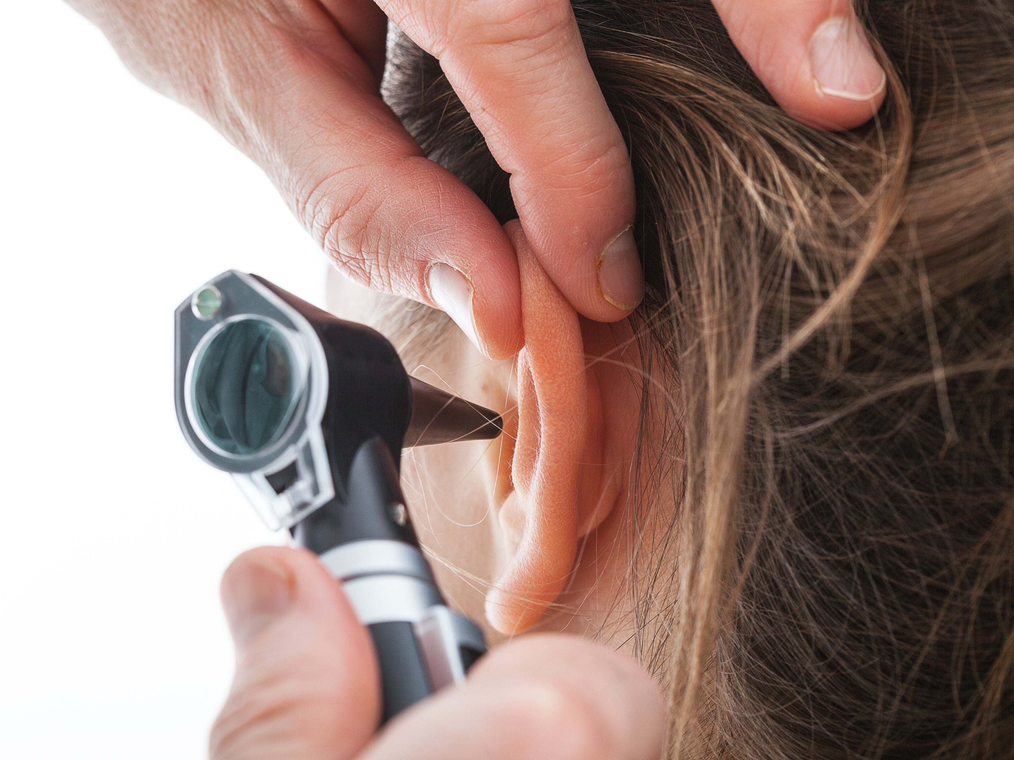 An ear exam being carried out with an otoscope