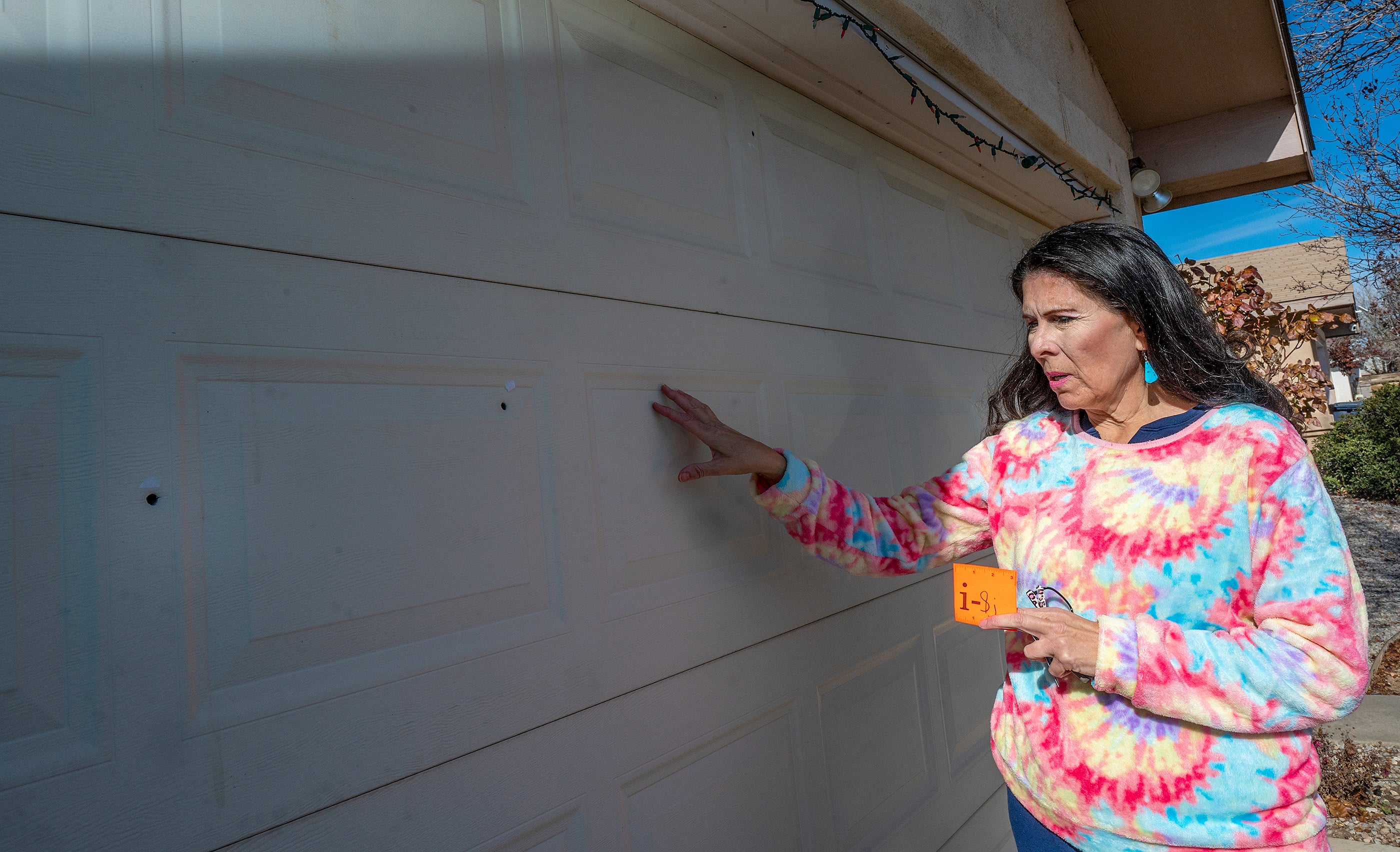 New Mexico state senator Linda Lopez shows bullet holes in her garage door after her home was shot at last month.