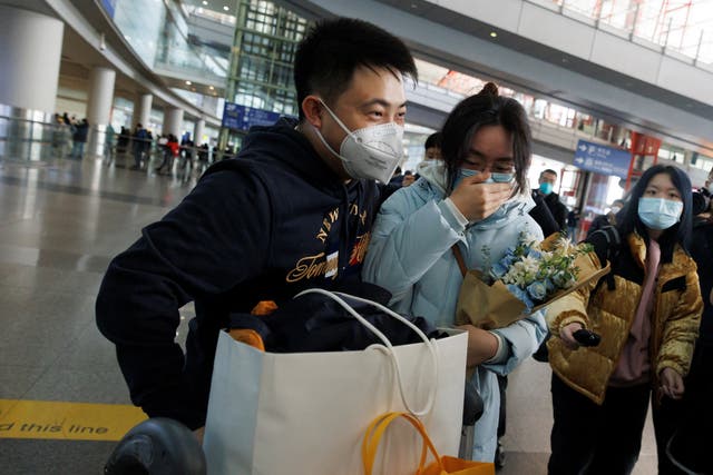 <p>People embrace at the international arrivals gate at Beijing Capital International Airport after China lifted the coronavirus disease</p>