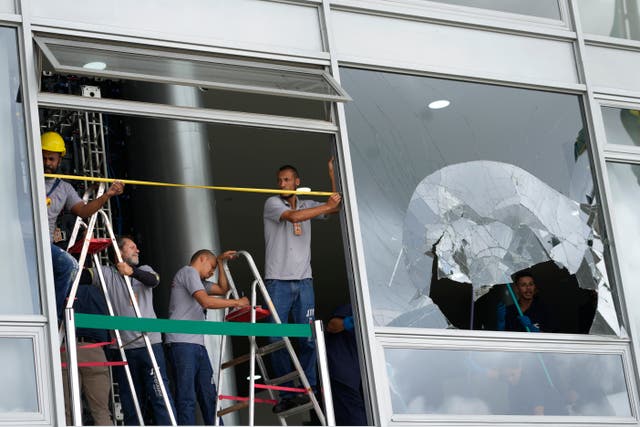 <p>Wrokers measure the windows of Planalto Palace, the office of the president, the day after it was stormed by supporters of former president Jair Bolsonaro </p>