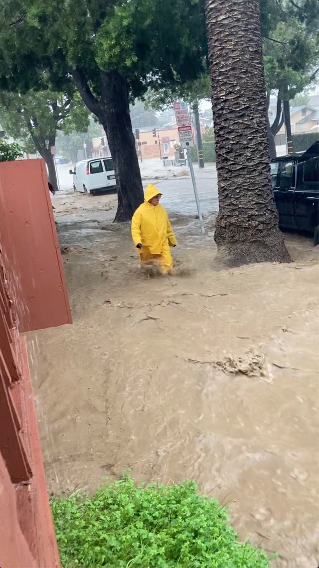 <p>A person wades through streaming flood water, in Santa Barbara, California on January 9, 2023</p>